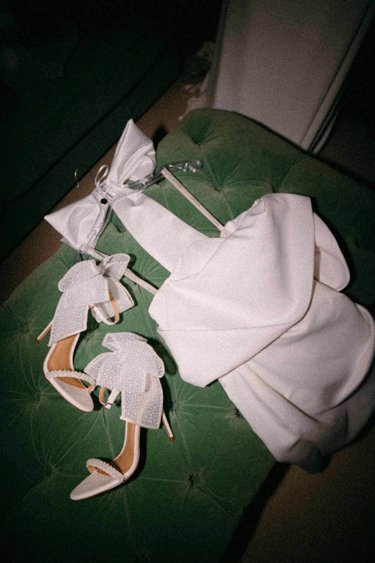 Wedding accessories including white heels and bow details arranged on green surface. Aberdeen wedding photographer, Douneside house