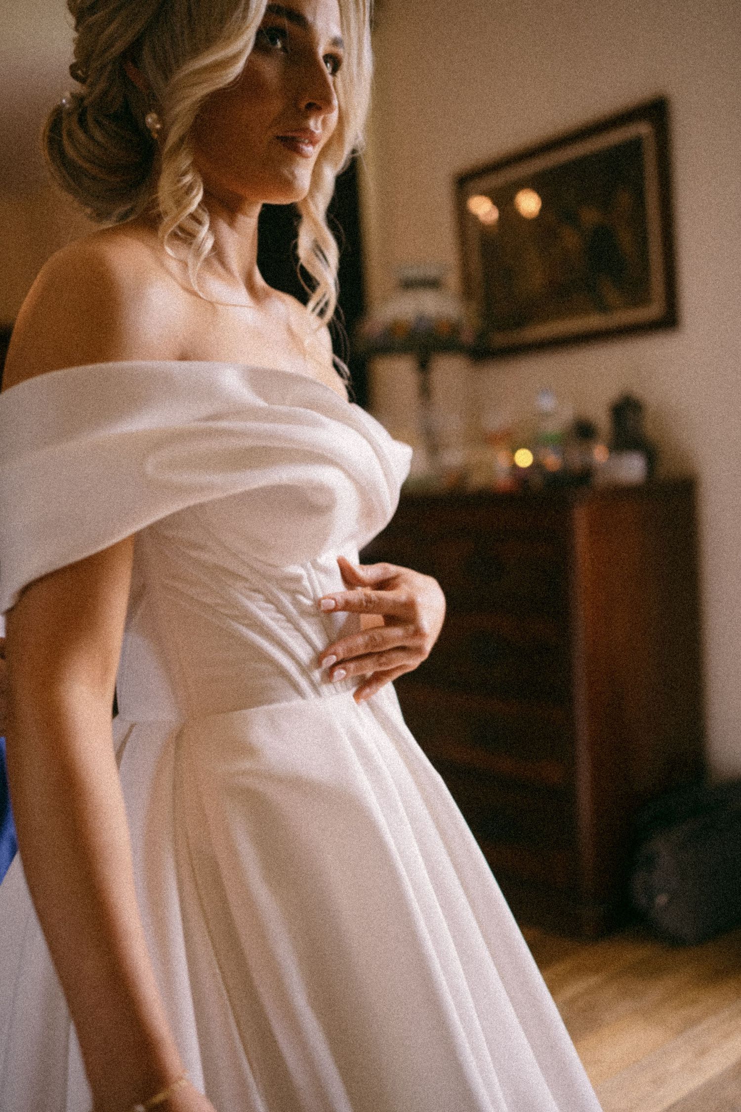 Elegant off-shoulder white wedding dress with flowing fabric shown in detail.  Aberdeen wedding photographer, Logie country house