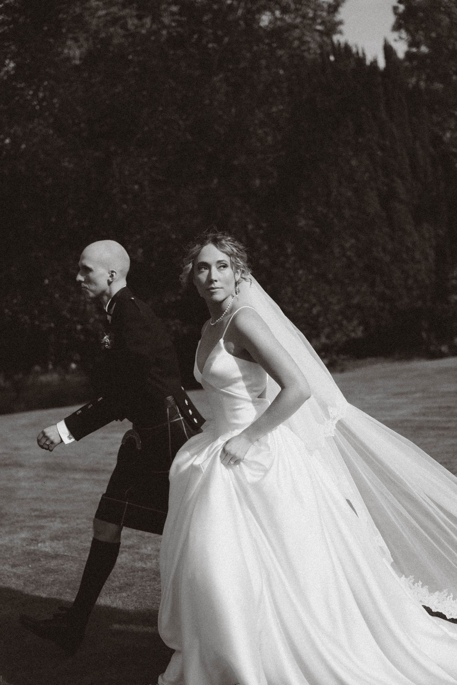 Black and white wedding photography sequence shows a couple spinning and dancing together in an ethereal setting.