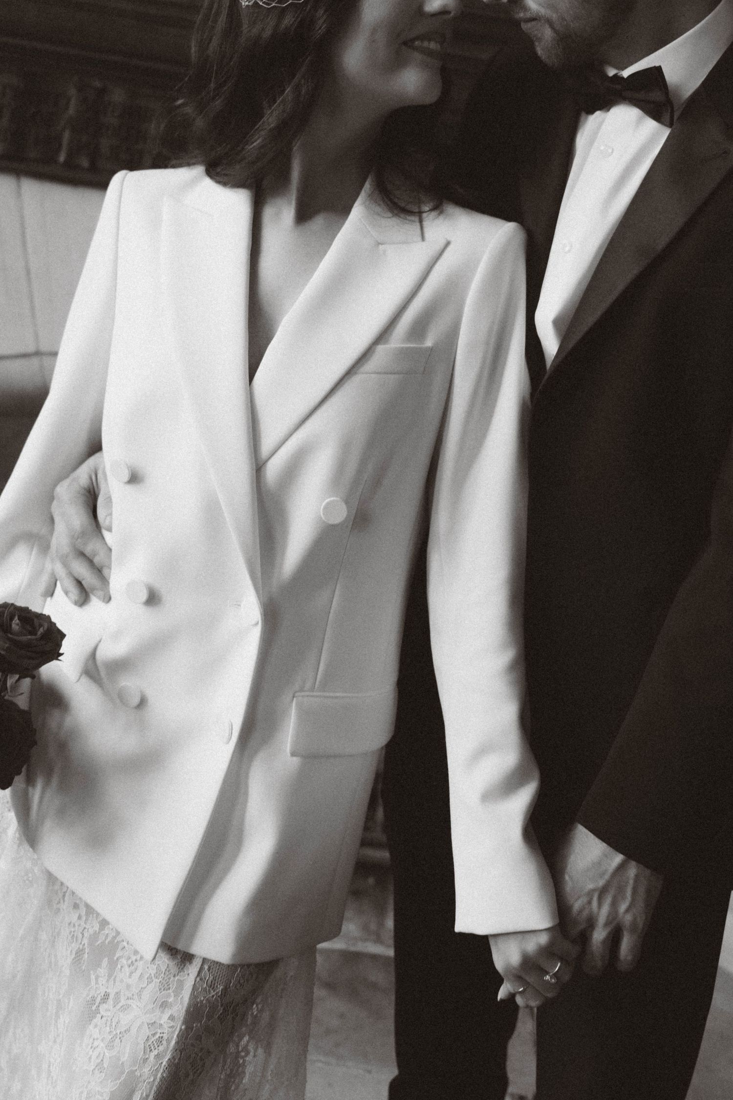 Black and white photo series showing formal attire details with white blazers and lace accents.