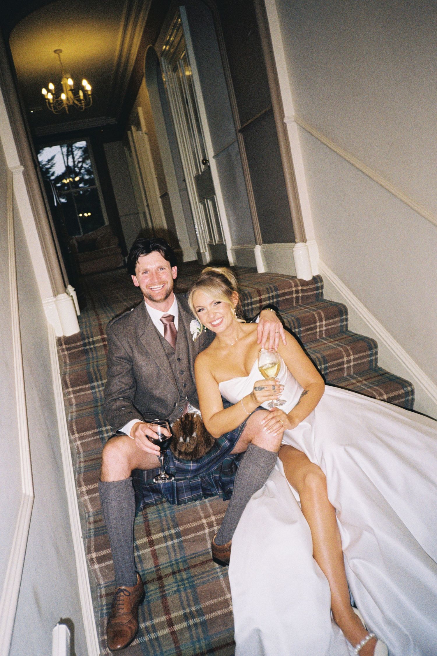 A series of four candid photos showing a couple in wedding attire sitting on a patterned couch in a hallway.