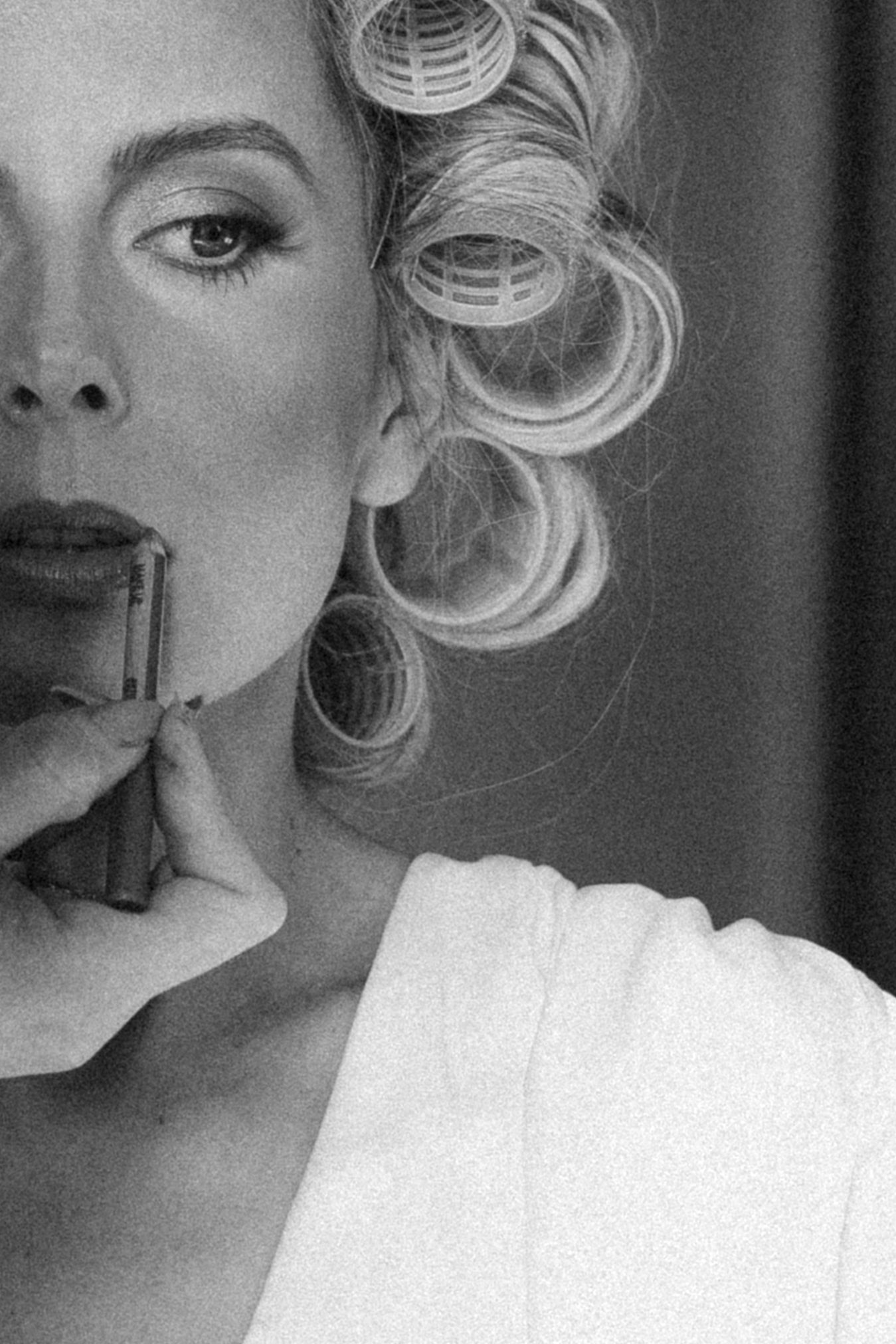 Artistic black and white portrait showing vintage-inspired curled hairstyle and makeup.
