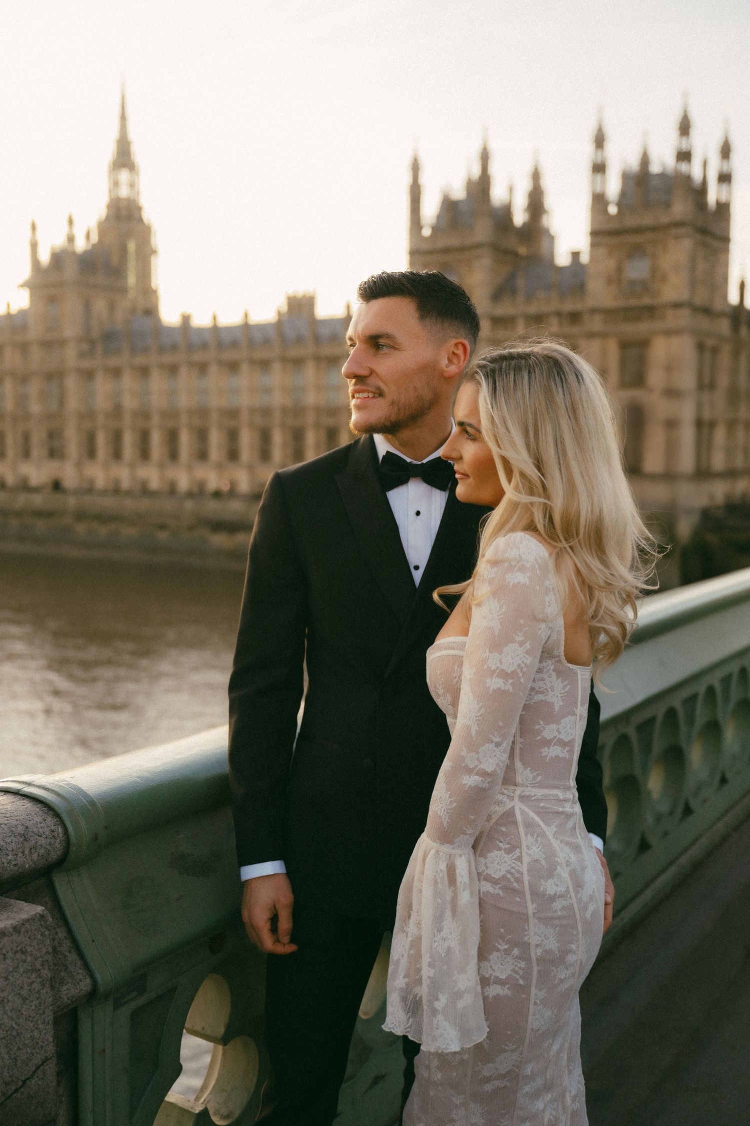 A couple shares romantic moments on Westminster Bridge with the Houses of Parliament visible in the background.