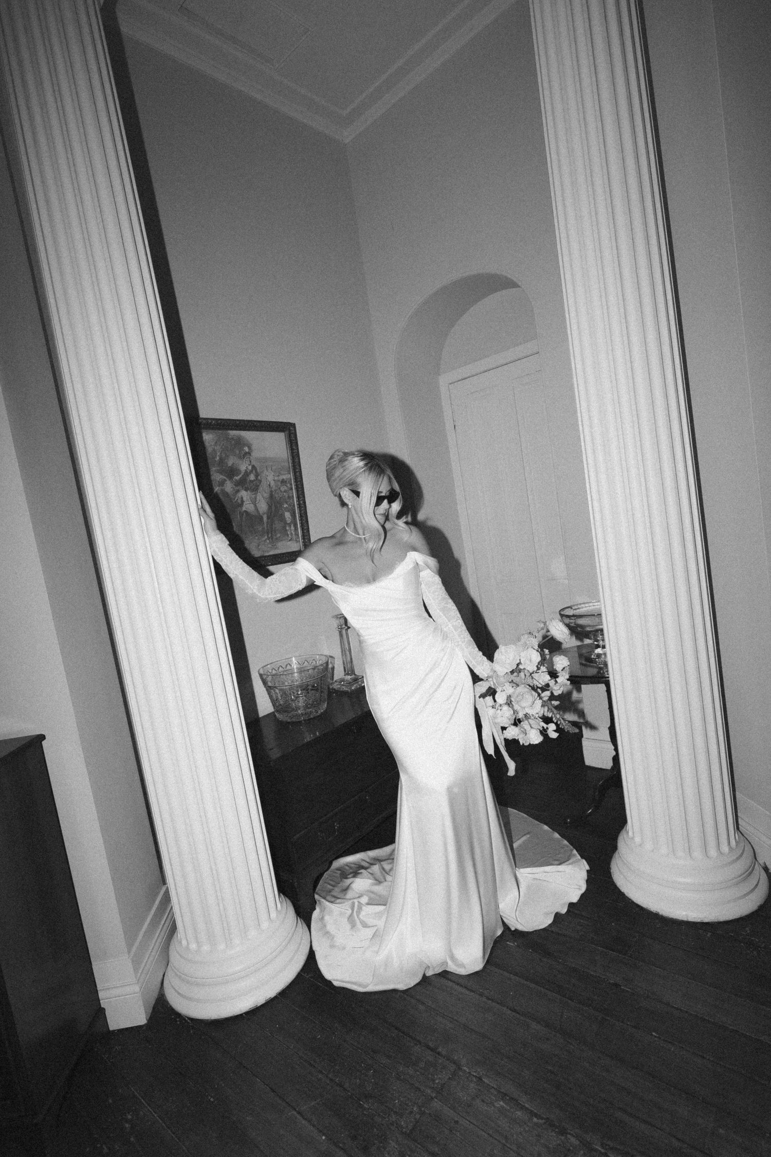 Black and white photos of sculptures or white columns against a dark wall creating a dramatic architectural display.