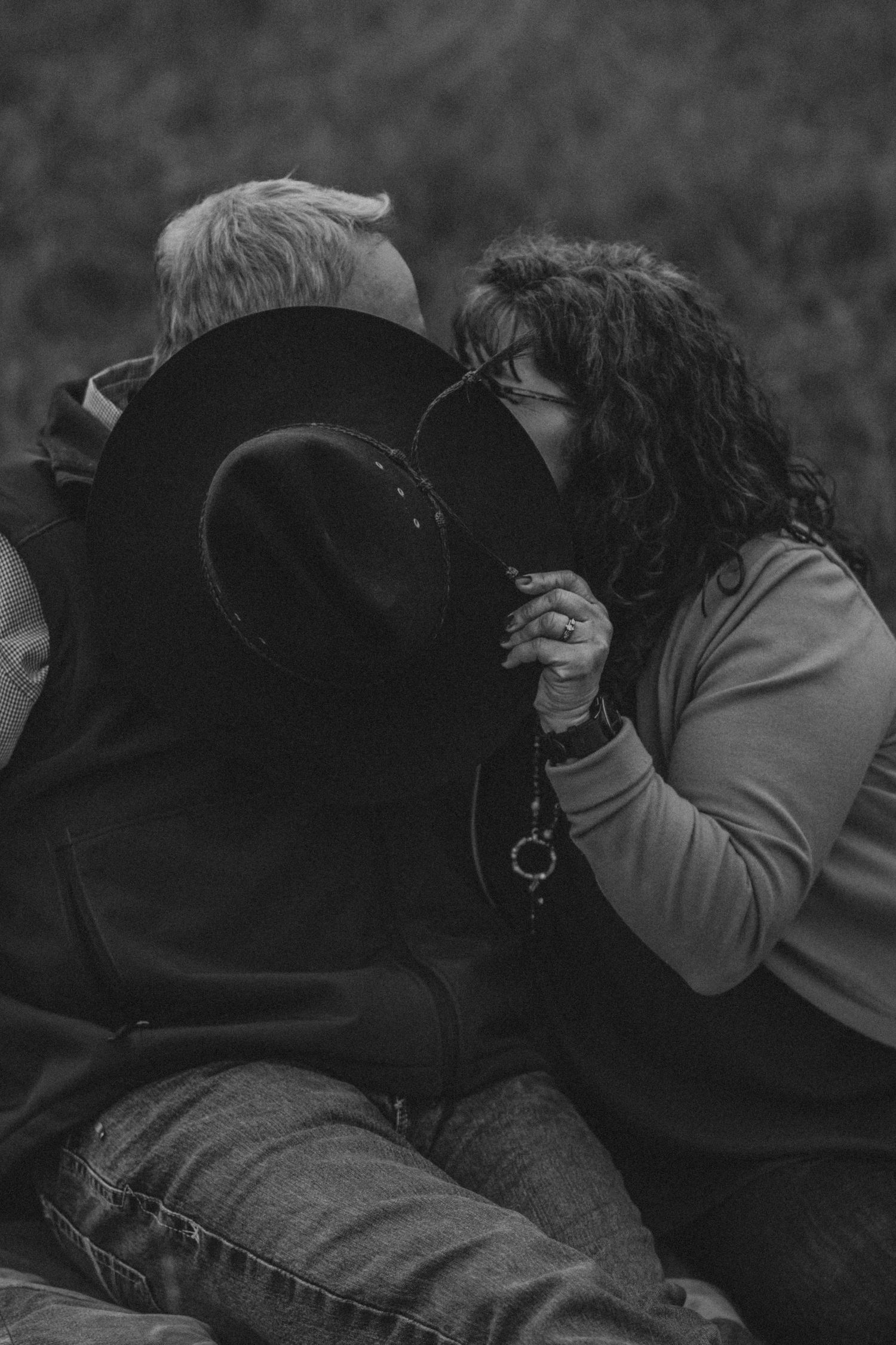 Two people share an intimate moment together in black and white monochromatic photography.