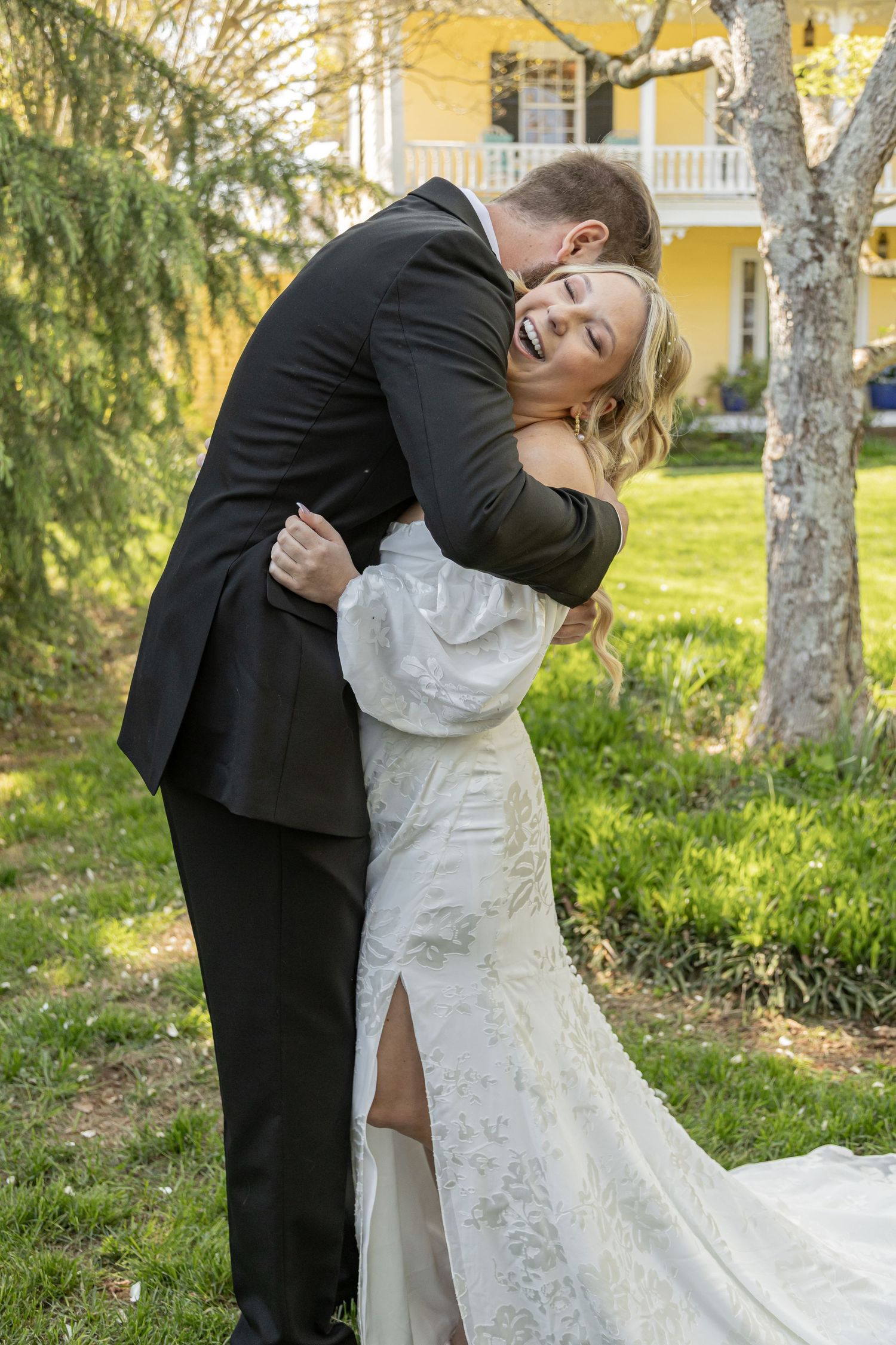 Romantic wedding couple dancing and dipping in a garden setting.