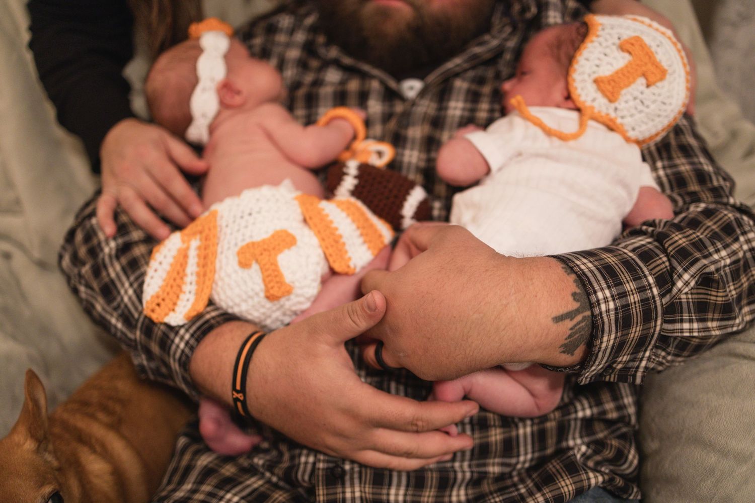 Close-up shots of a baby wearing an orange and white outfit being embraced.