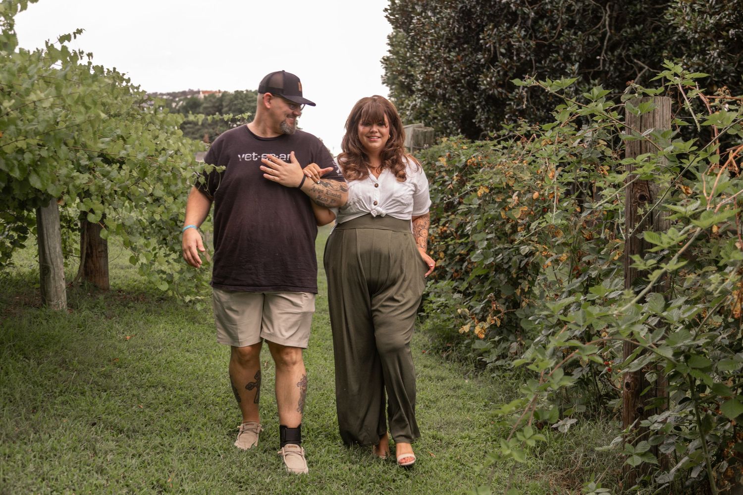 A couple walks together through a lush garden pathway.