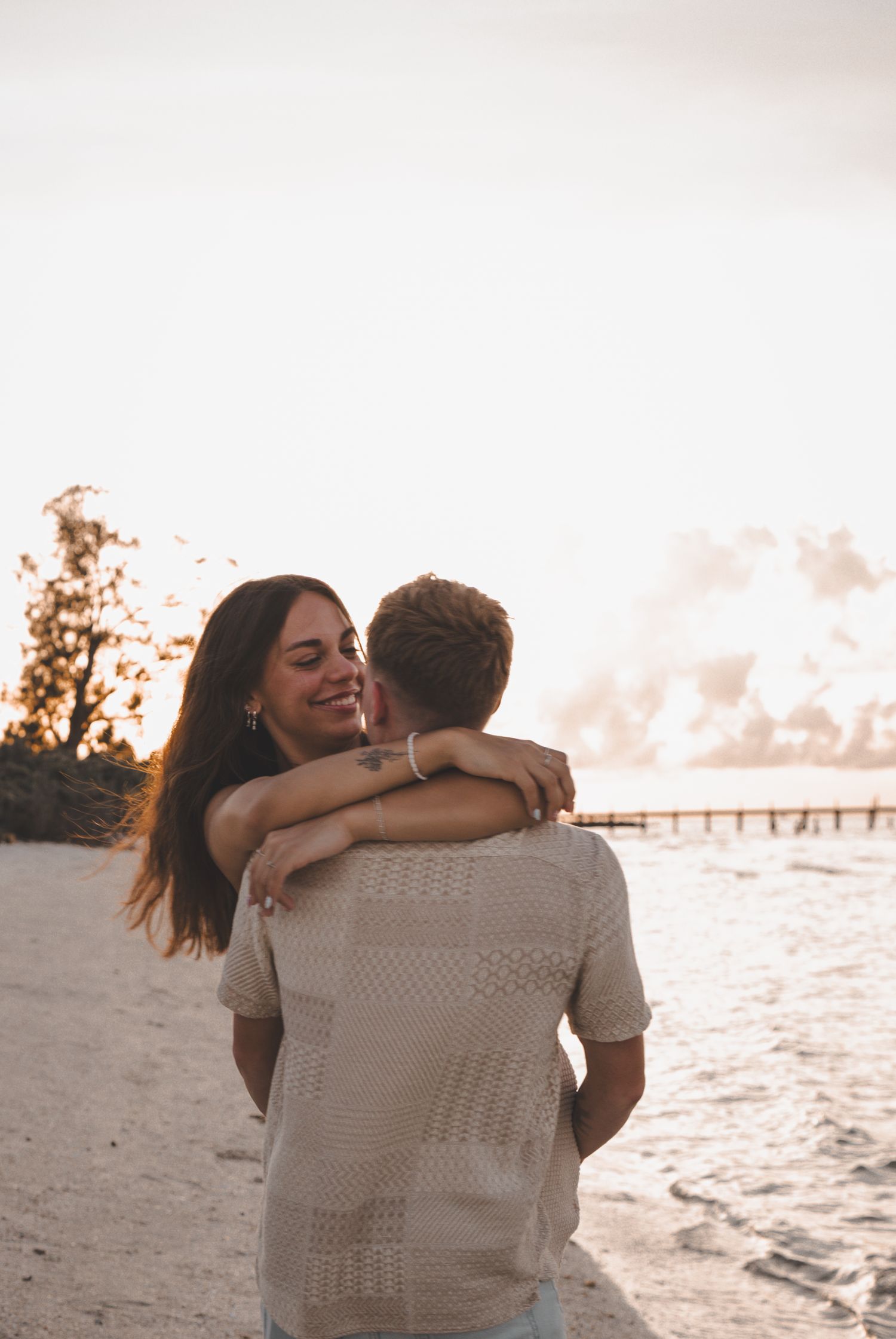 Sunset beach embrace with warm golden light and ocean views.