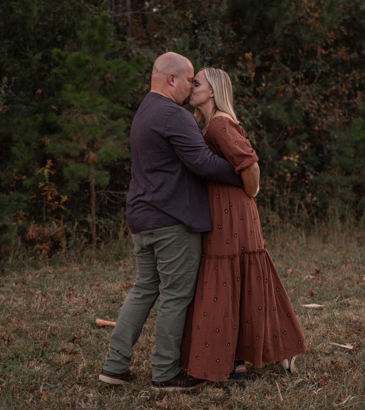 Intimate family moments captured in a rustic field during sunset.
