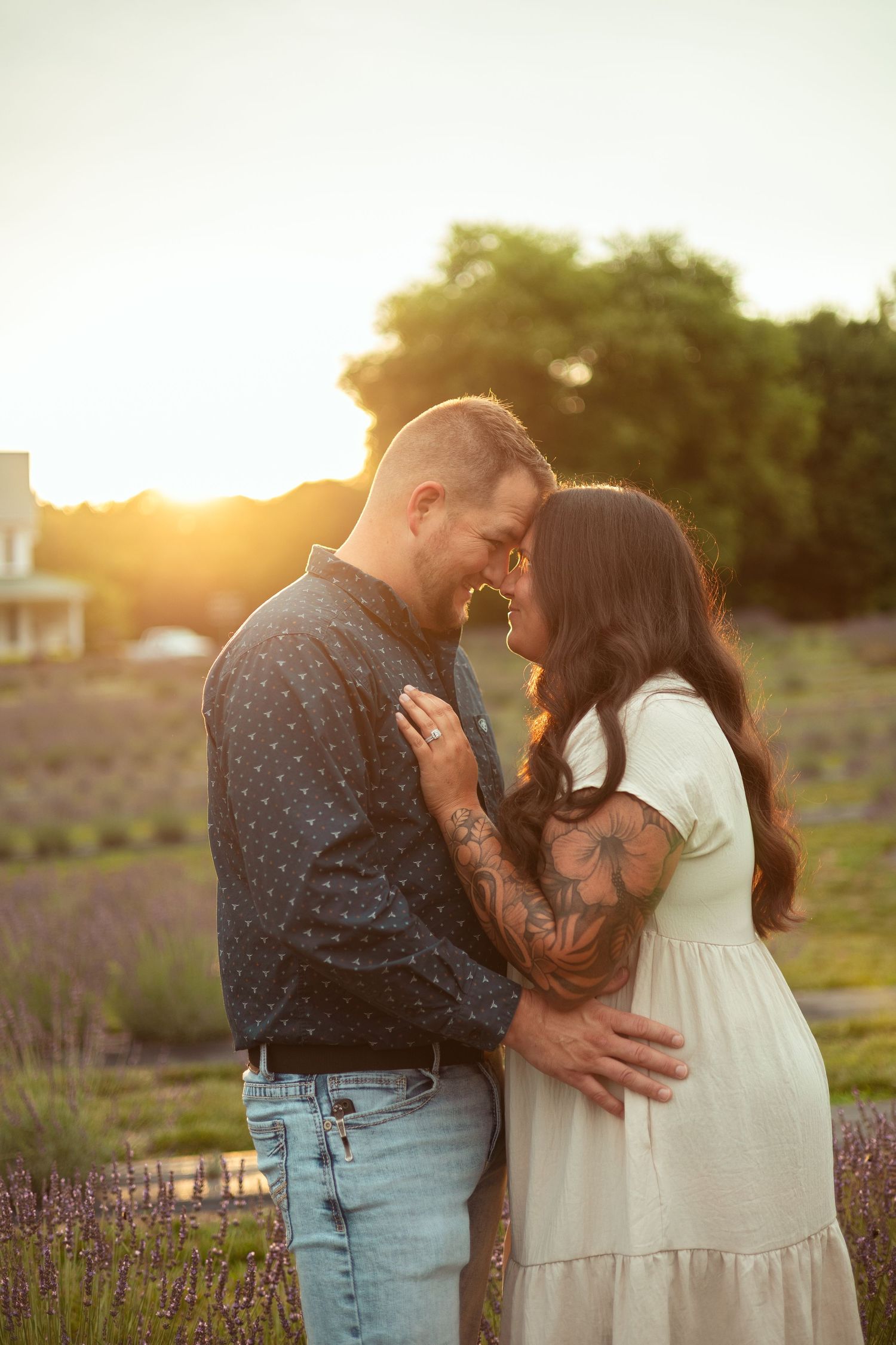 Couple embracing and touching foreheads at golden sunset in a lavender field.