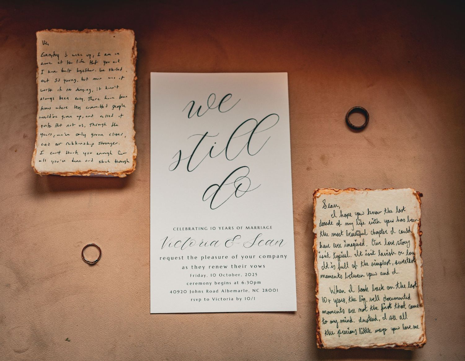 Wedding stationery and handwritten notes displayed against a warm-toned wall with geometric line designs.