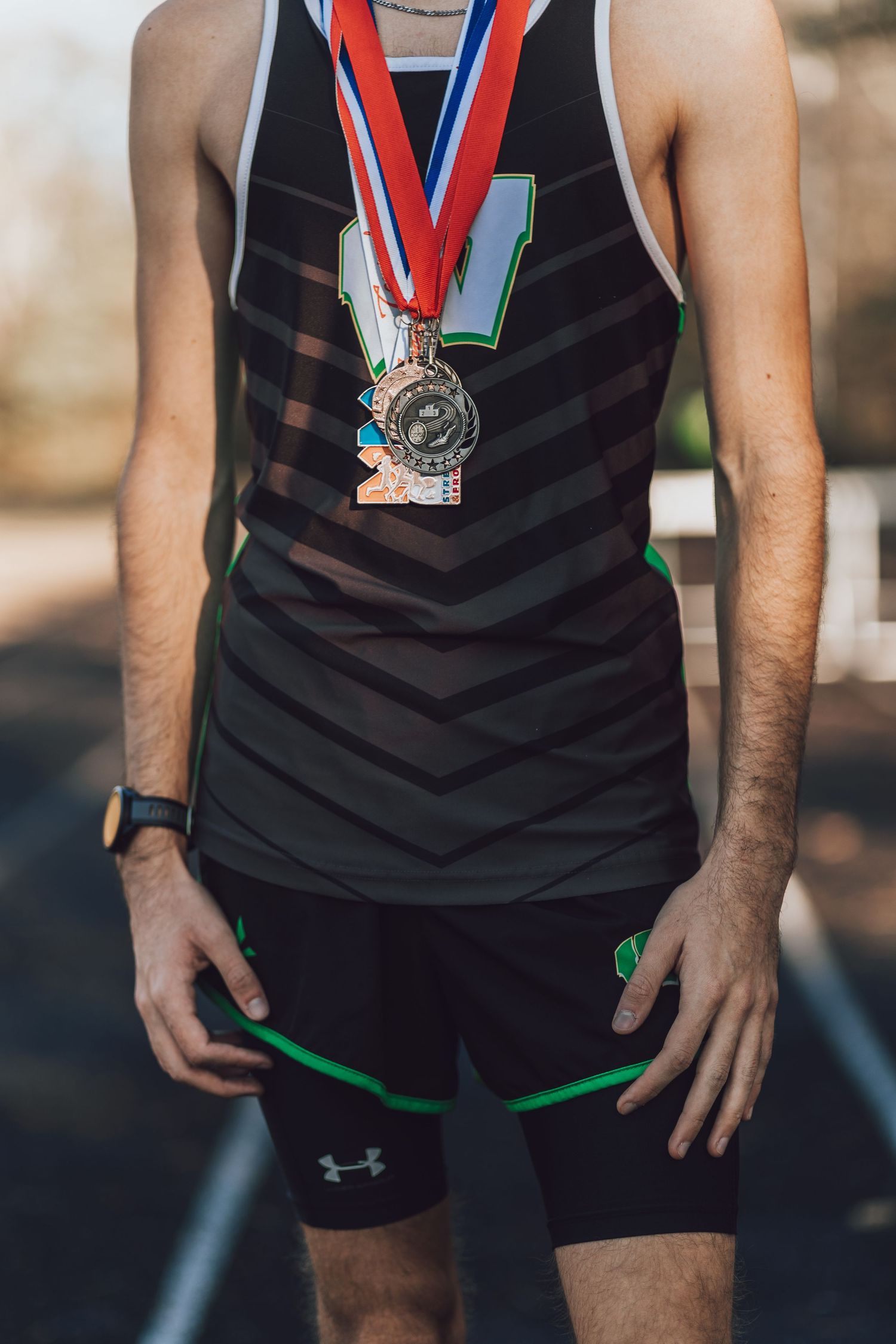 Close-up of athletic medals and sportswear showing achievement in competition.