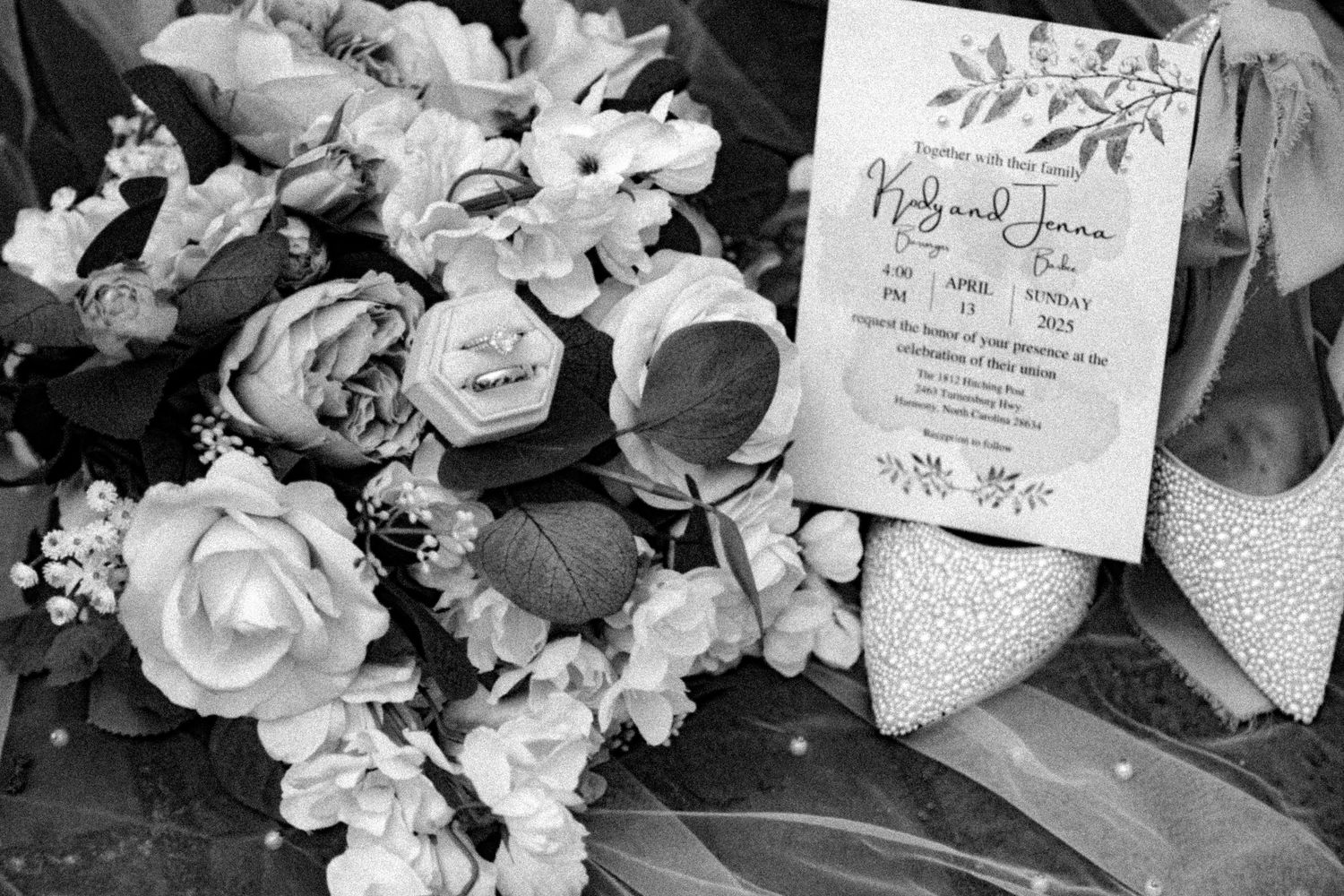 Wedding details including floral arrangements, invitations, and accessories laid out in black and white.