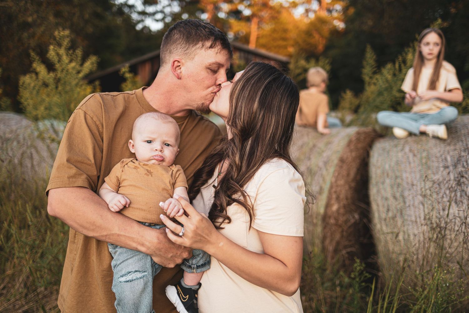 A family poses together in a natural outdoor setting during a fall photo session.