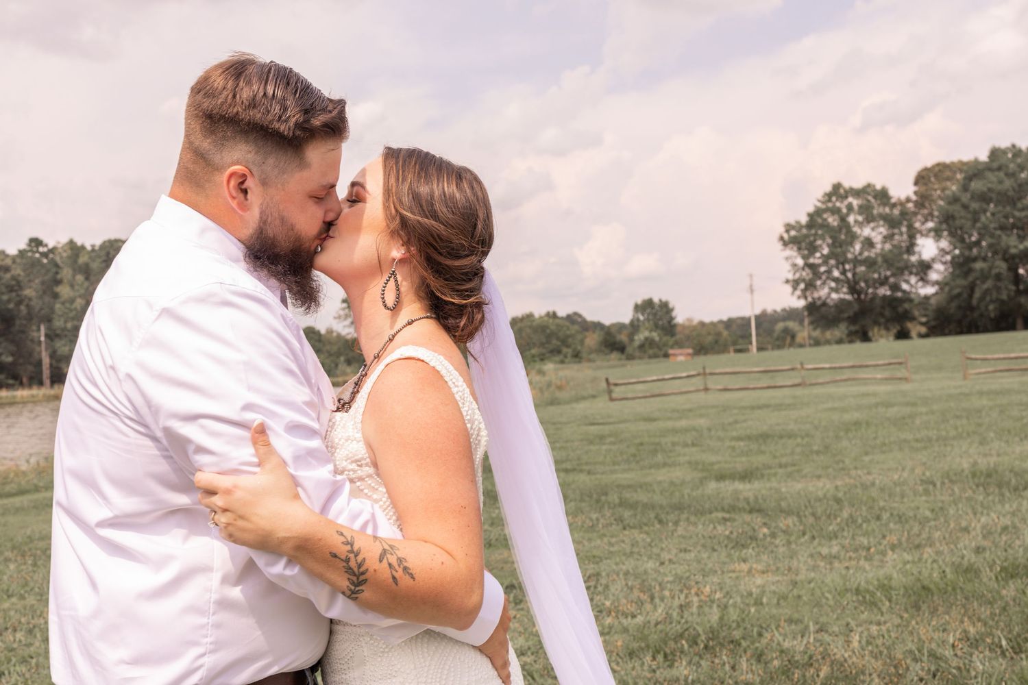 Couple in white wedding attire share intimate moments in a series of photos taken in a grassy field at sunset.