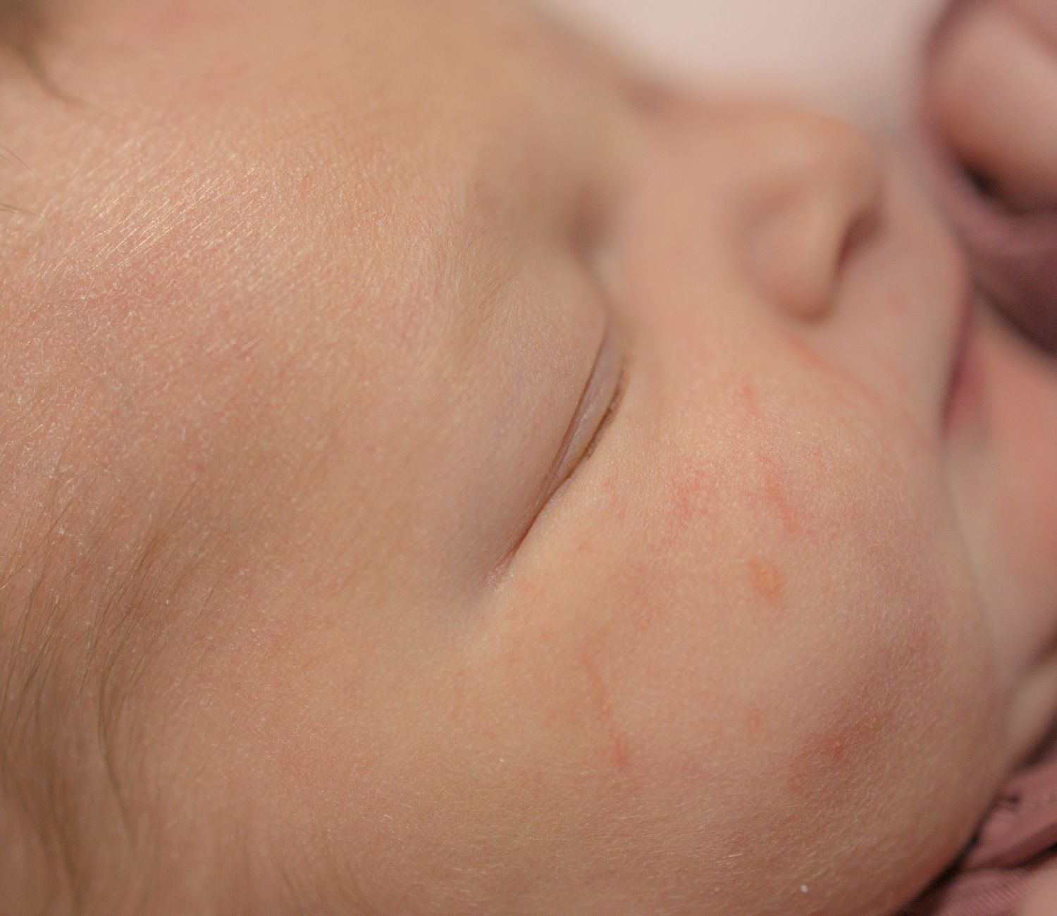 Close up view of a baby's peaceful sleeping face showing smooth skin and closed eyes.