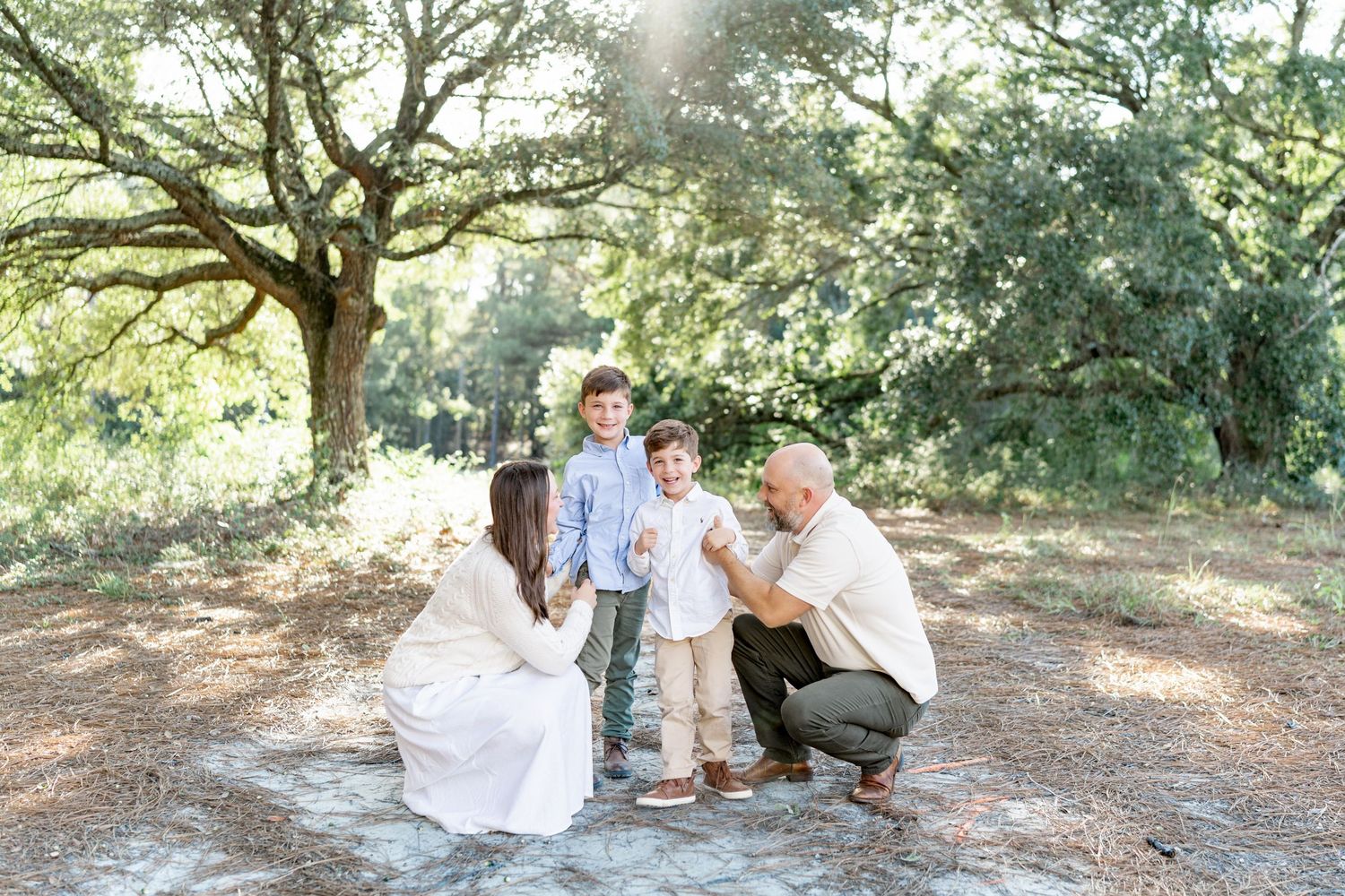 A family gathering under large oak trees for casual outdoor photos located in Hattiesburg, Mississippi