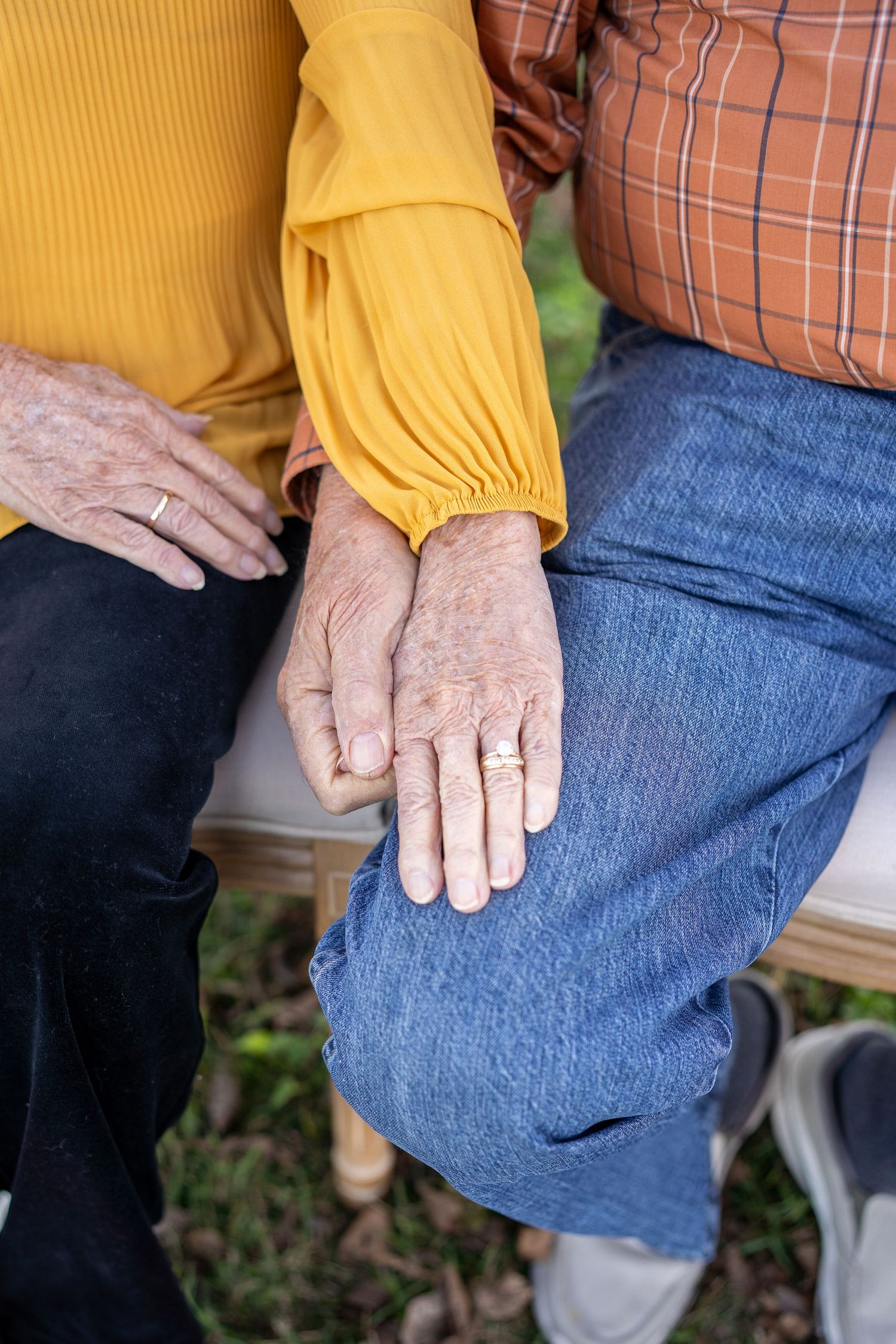 Close-up sequence showing hands resting on blue denim jeans while wearing a yellow long-sleeved shirt and plaid top.