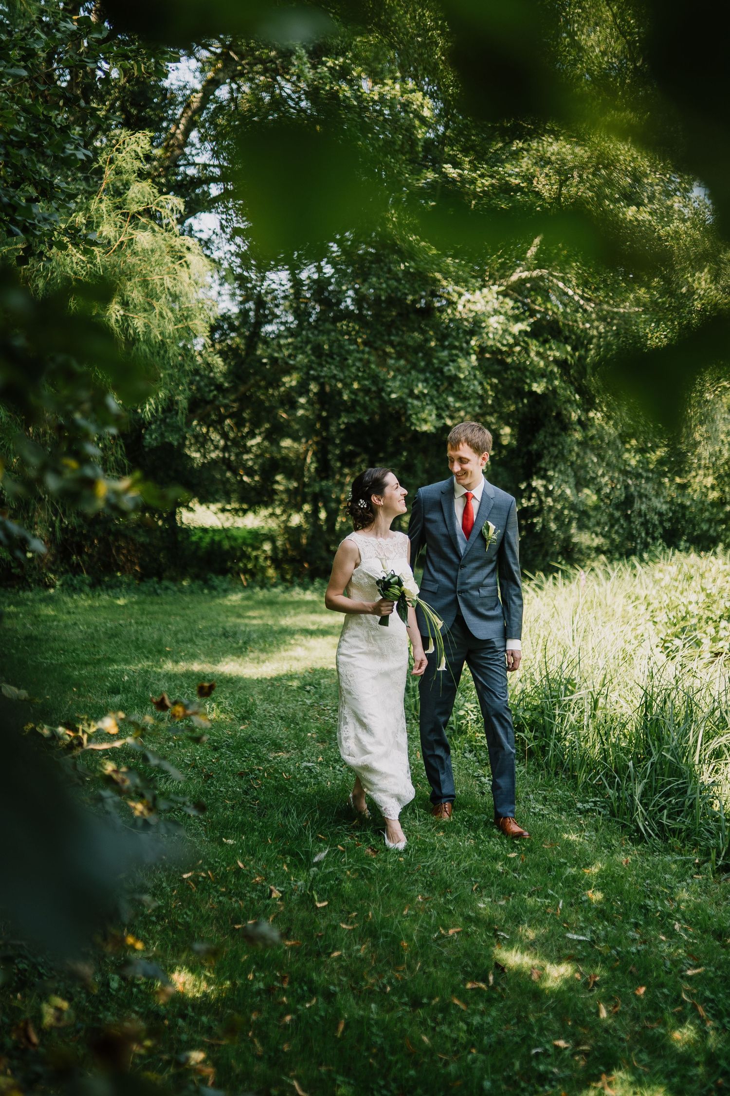 Wedding couple walking in a forest, looking at each other and happy