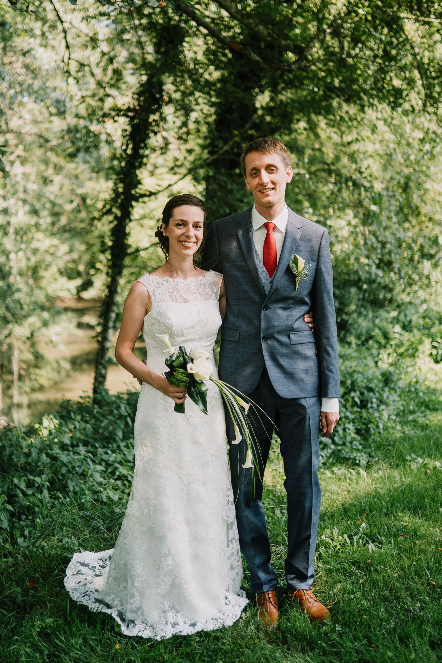 Classic photo of a wedding pair posing in the camera side by side in a forest