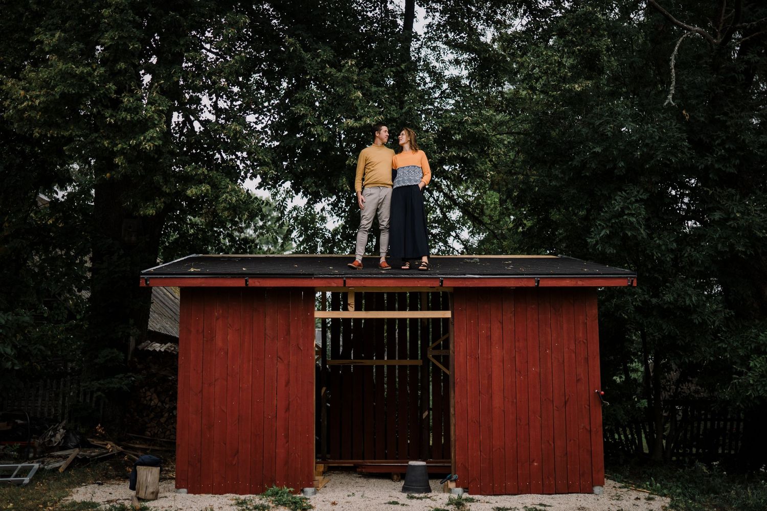 A couple standing on the roof of a shed