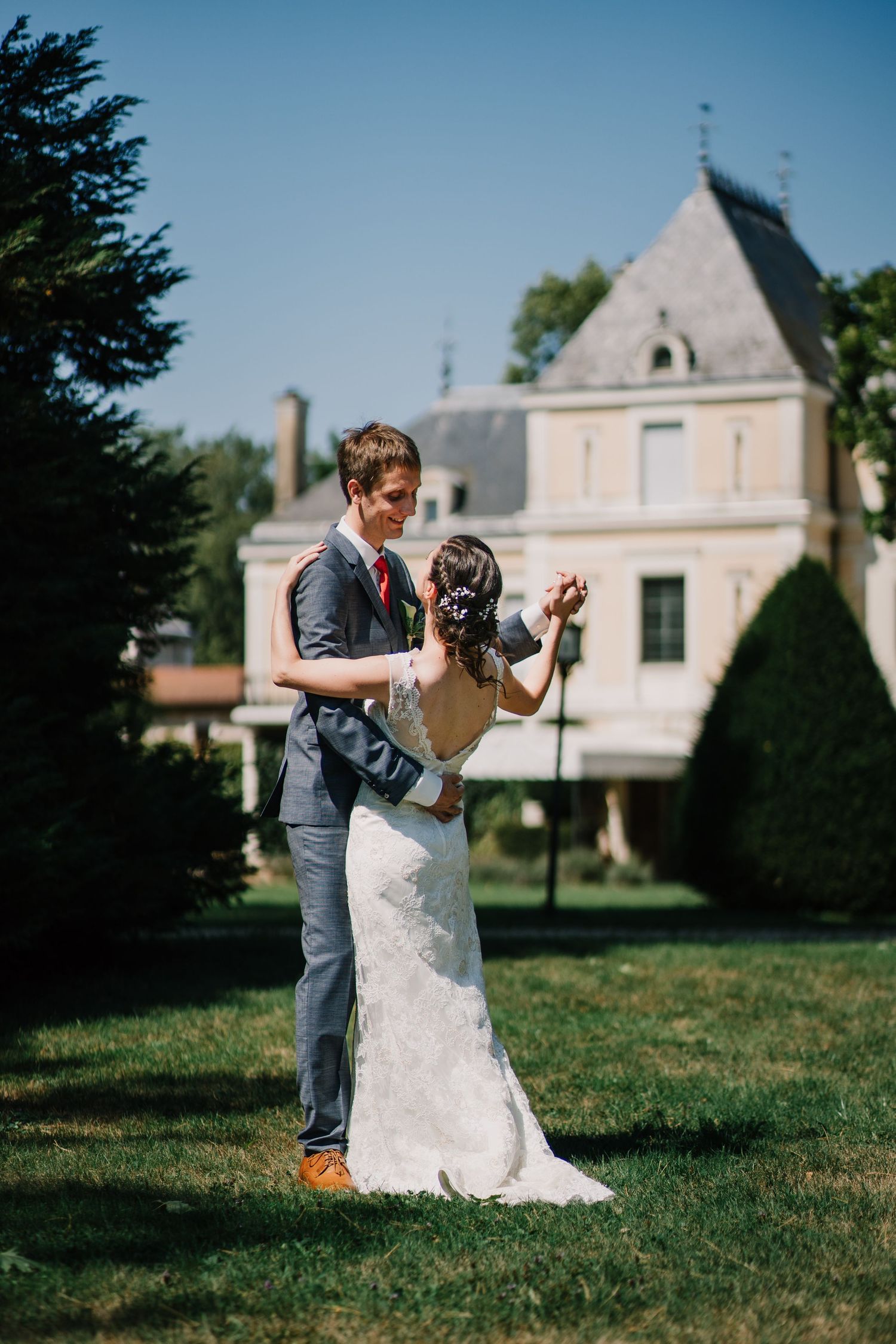 Romantic photo of a wedding couple dancing in front of a castle