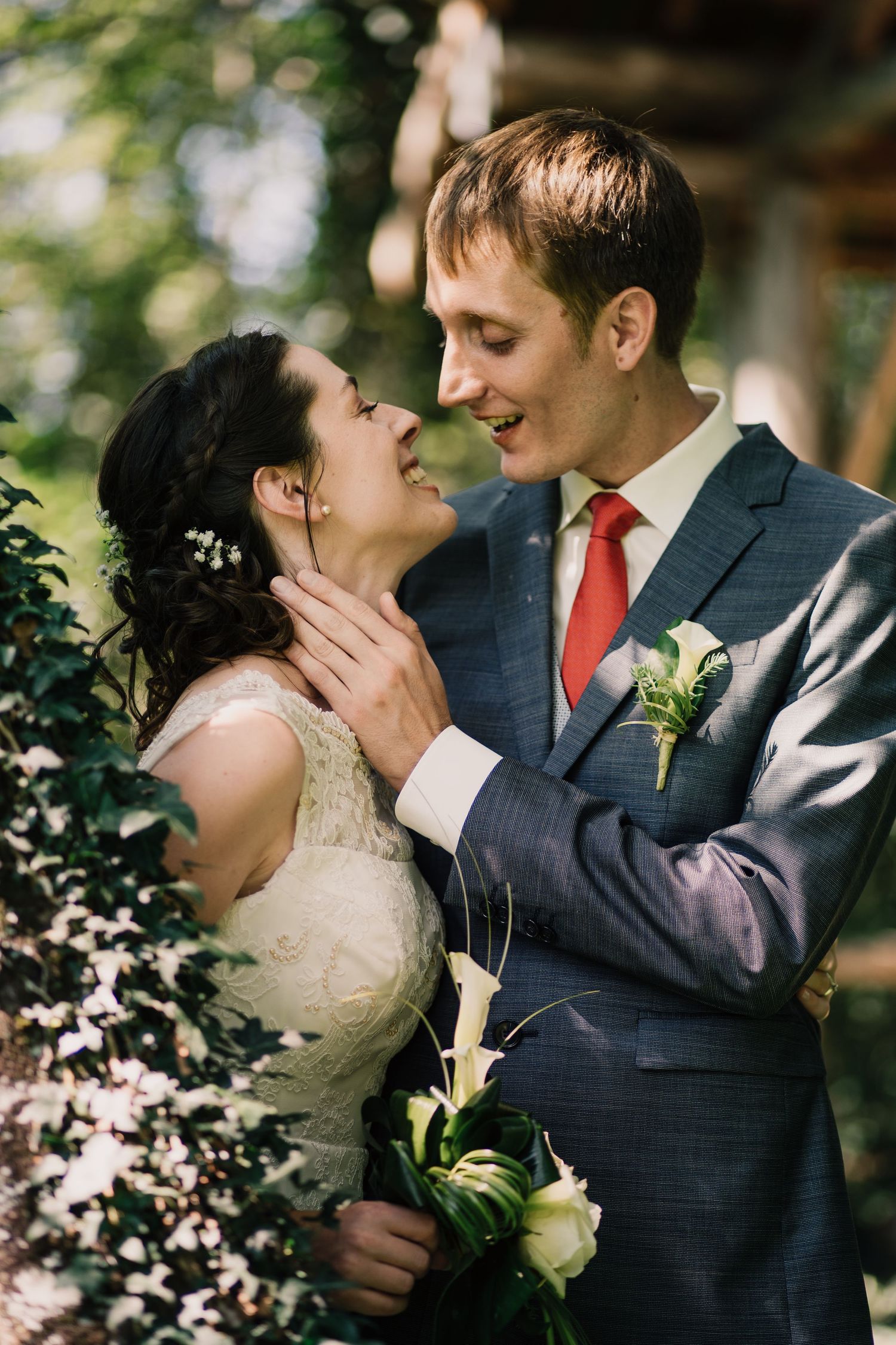 Wedding photo of a couple smiling and about to kiss under a tree