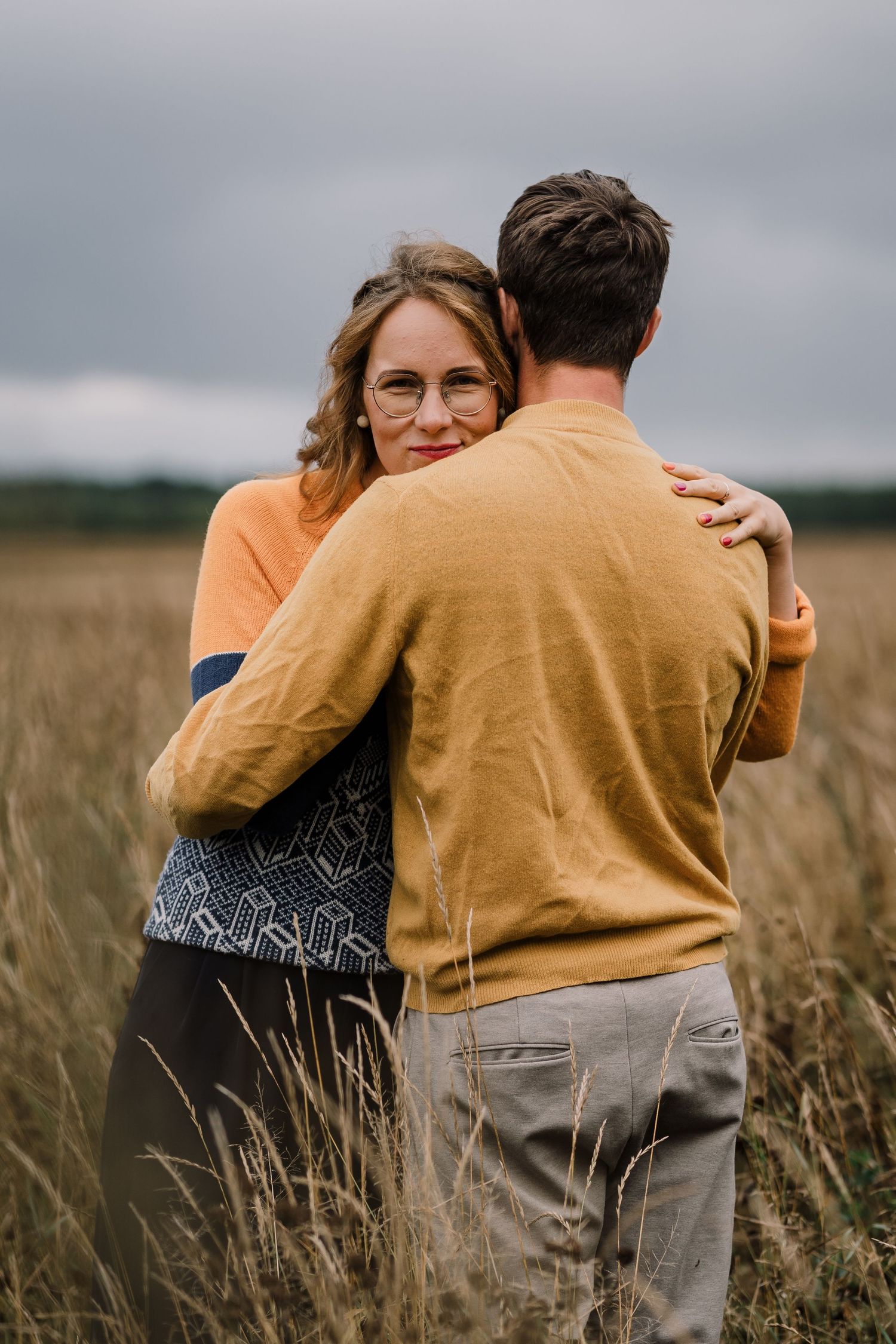 A couple hugging in a field, romantic photoshoot with autumny vibes