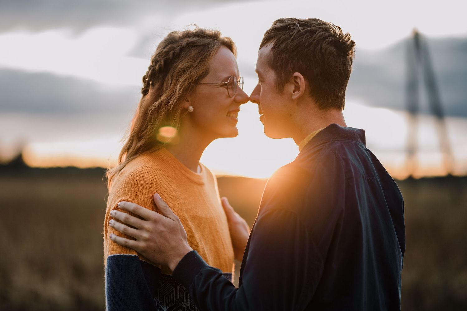 A romantic moment of a couple looking at each other and smiling in sunset