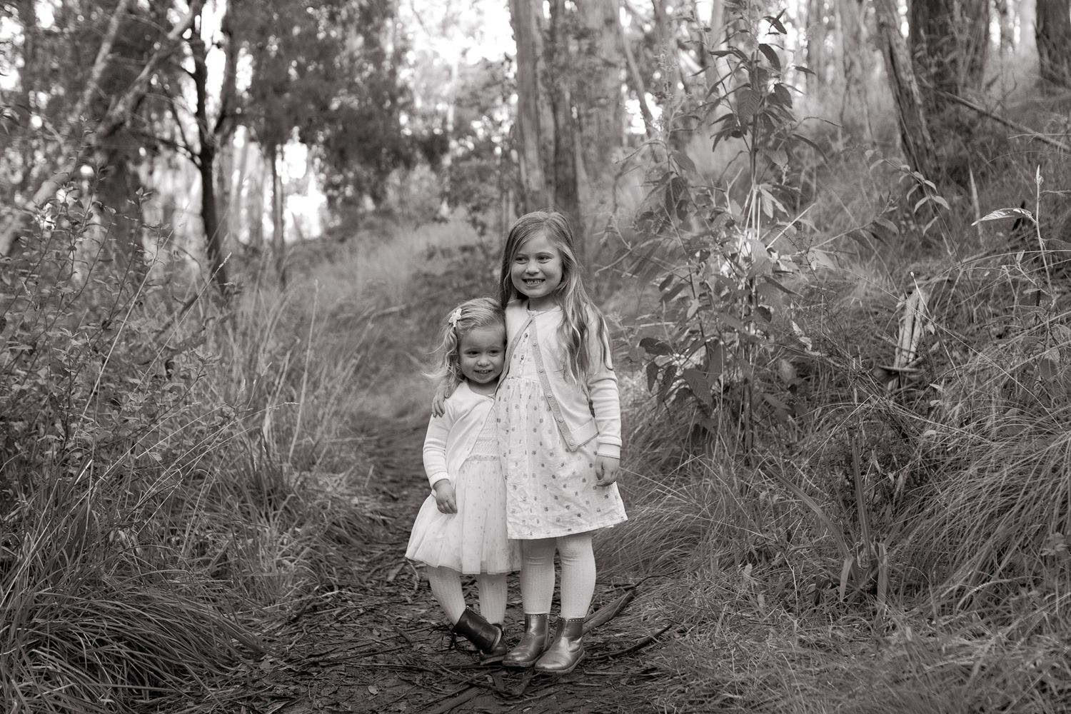 Sisters holding hands in the bushland whimsical and fairytale like outdoor family session Macedon Ranges Melb Vic