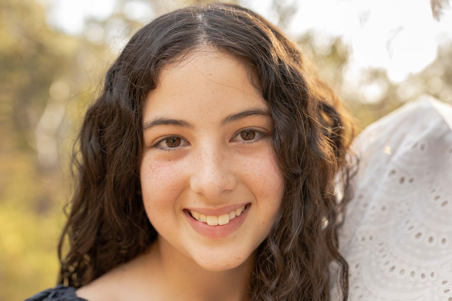 Close up pre teen smiling and looking into the camera warm sunlight outdoor family session Newport Lakes, Melb, Vic