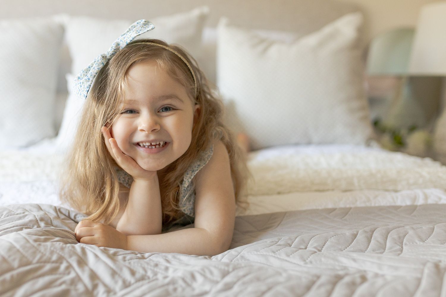 Big sister lying on the bed smiling happily at home newborn session Caroline Springs, Melbourne, Victoria