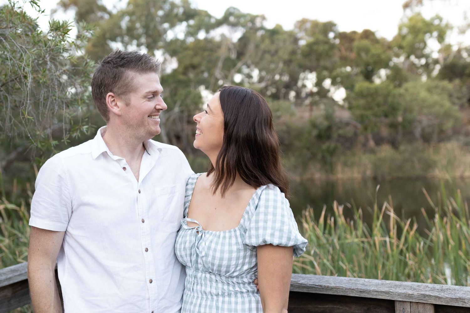 Couple looking and smiling at each other with the lake in the background. Outdoor family session Newport Lakes, Melbourne, Victoria