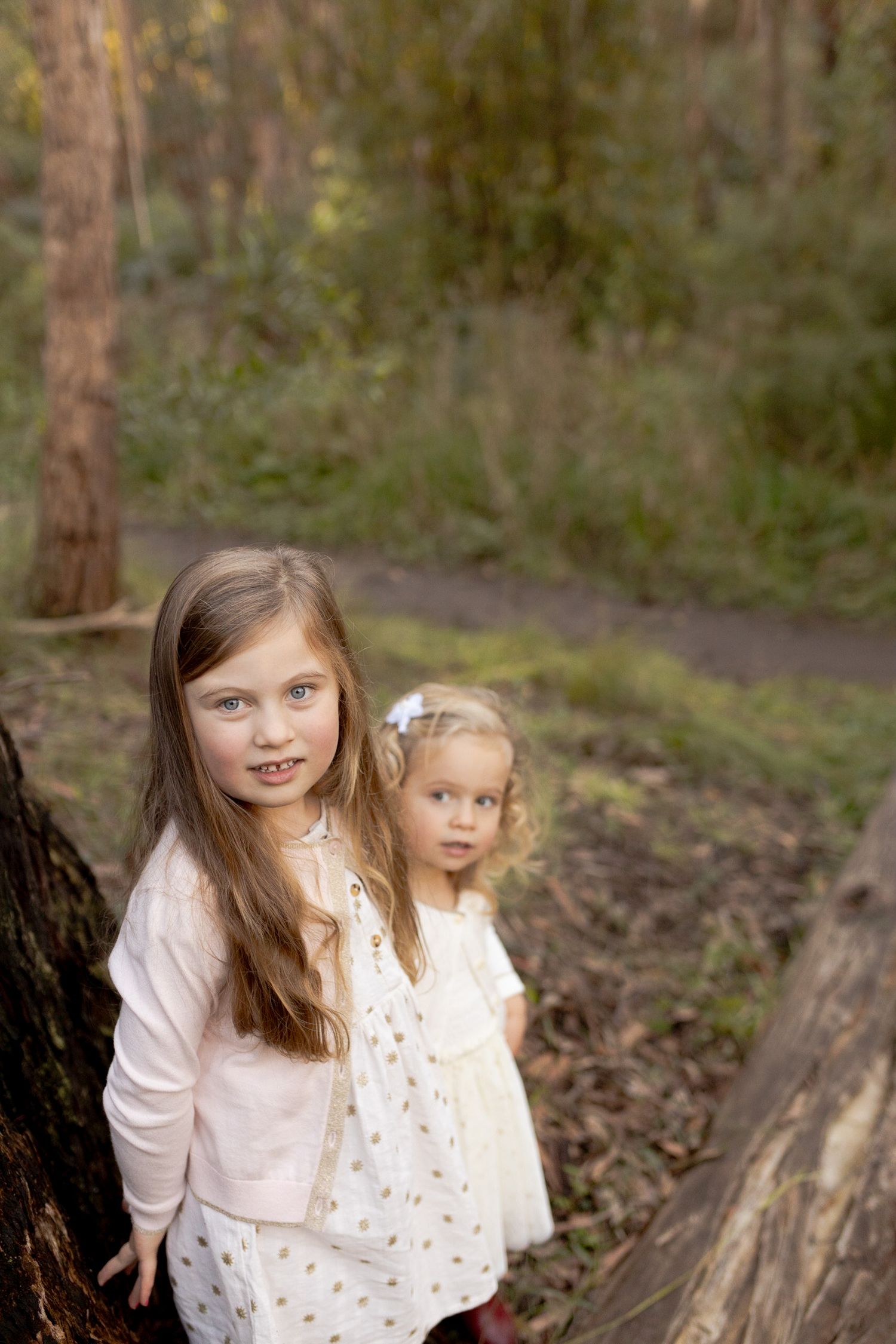 Sister look like they are hiding in a forest Outdoor family session Macedon Ranges Melb Vic