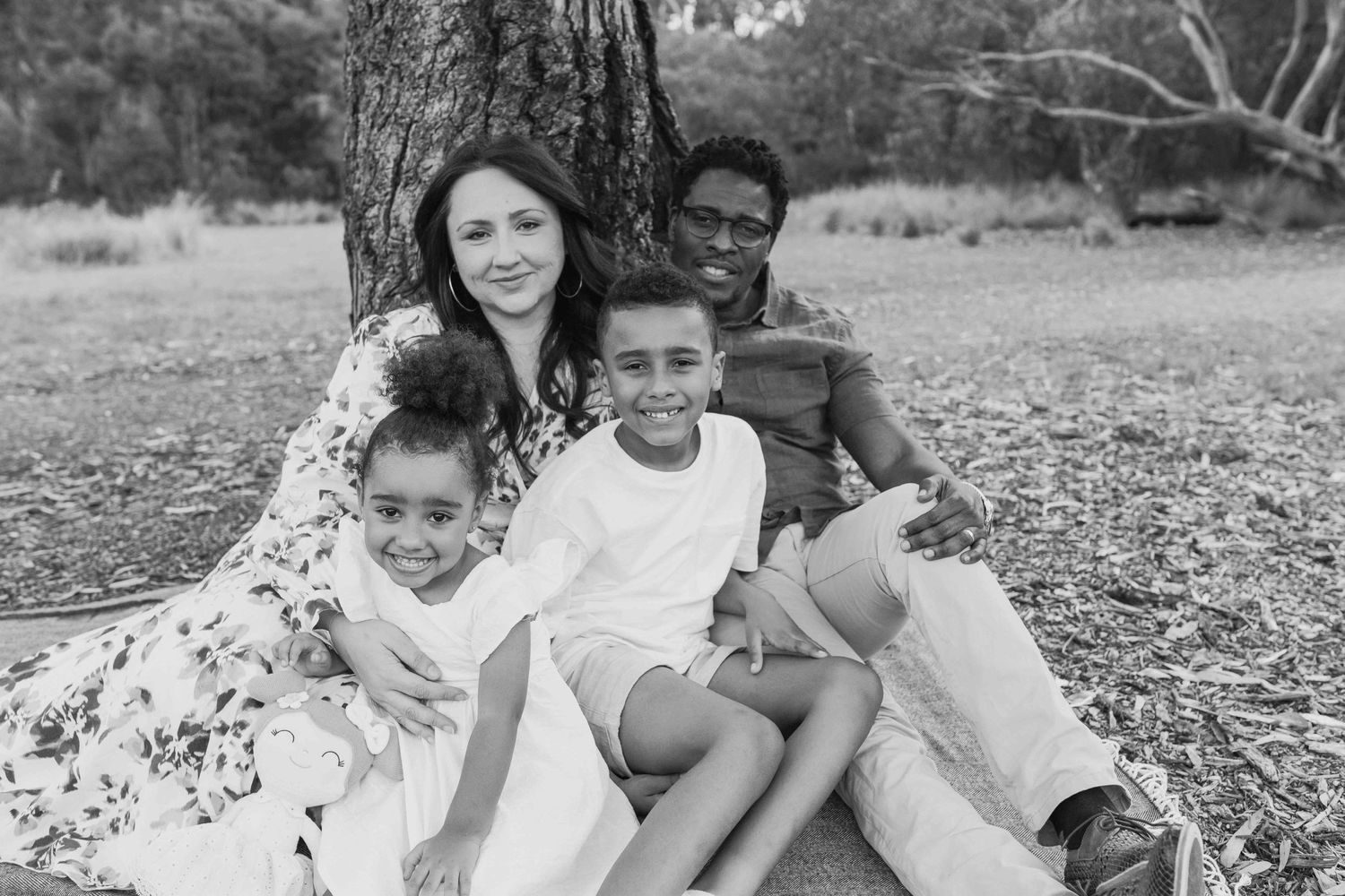 Family of four holding each other happily looking at each other. outdoor family session Newport Lakes, Melbourne, Victoria
