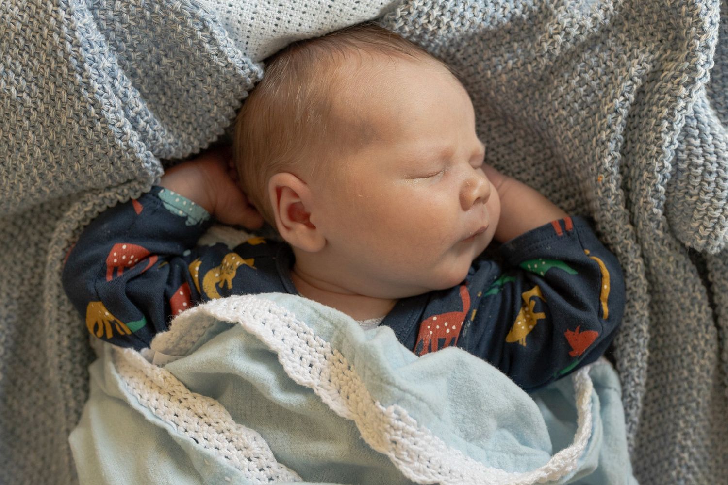 Newborn baby boy lying on the bed with soft blankets sleeping chubby cheeks at home newborn session  Moonee Ponds Melb Victoria