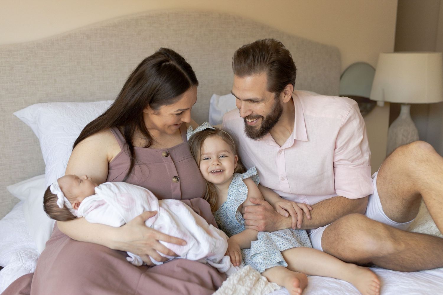Newborn at home session family of four lying on the bed hugging with baby girl. Caroline Springs, Melb, Vic