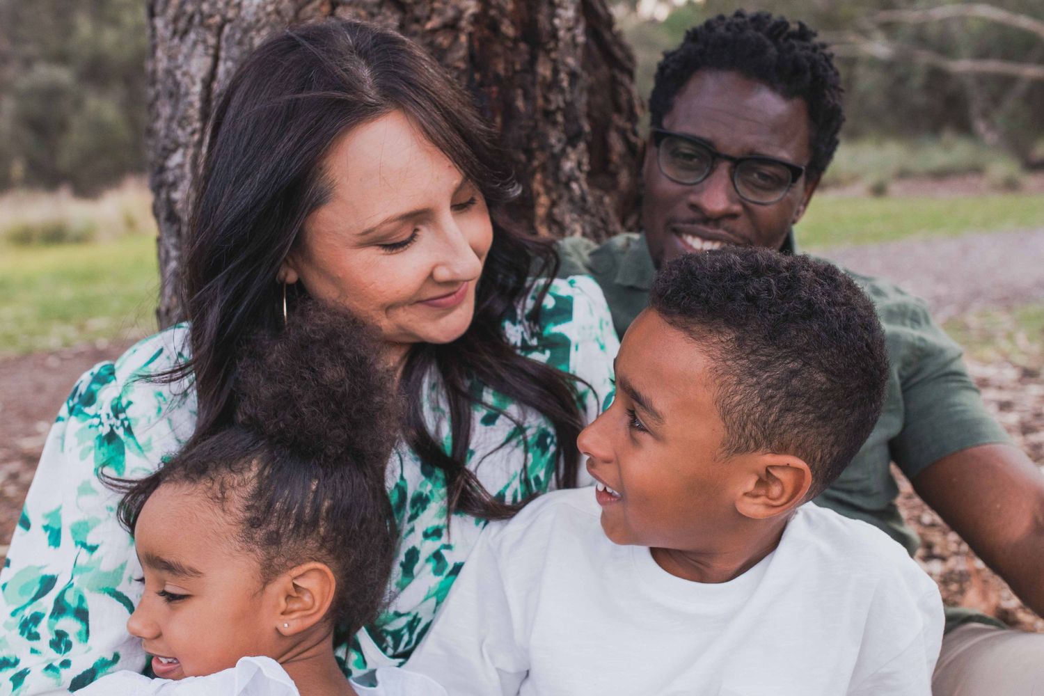 Family of four holding each other happily looking at each other. outdoor family session Newport Lakes, Melbourne, Victoria