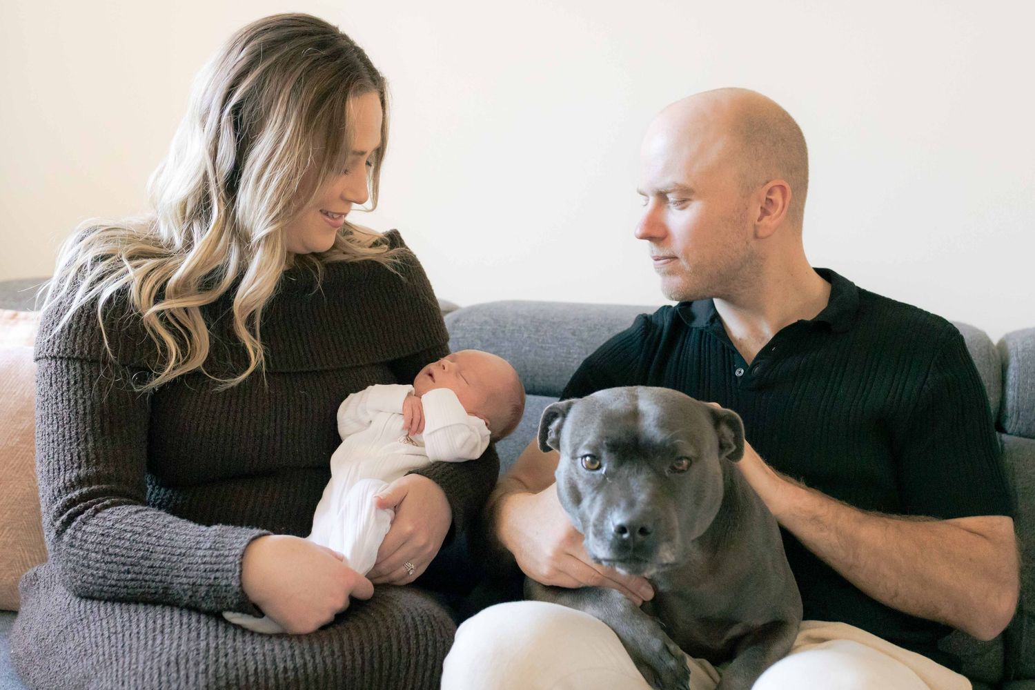 Parents newborn and dog sitting on the couch Melbourne Newborn Photography