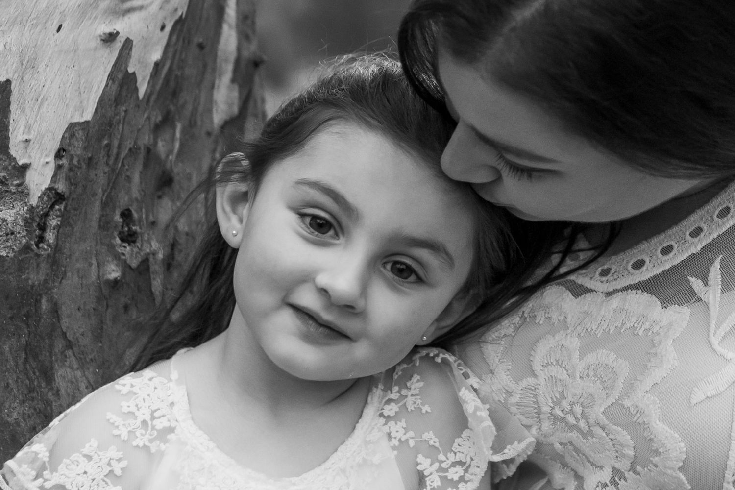 mum leaning down and kissing her daughter black and white family outdoor photography Avondale Heights Melbourne's West Family photographer
