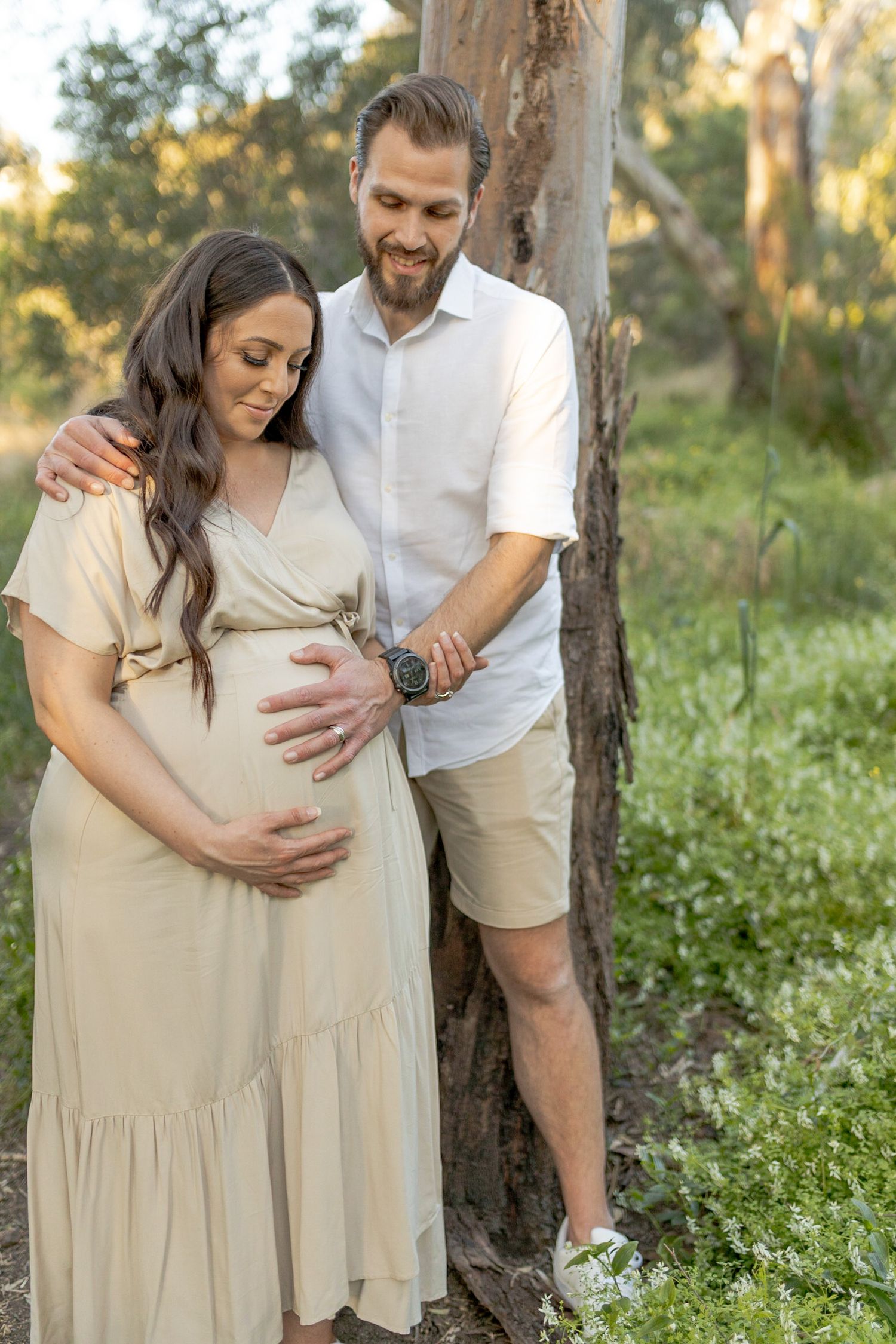husband and wife hugging and holding mum's belly outdoor maternity session Sunshine North, Melb, Vic