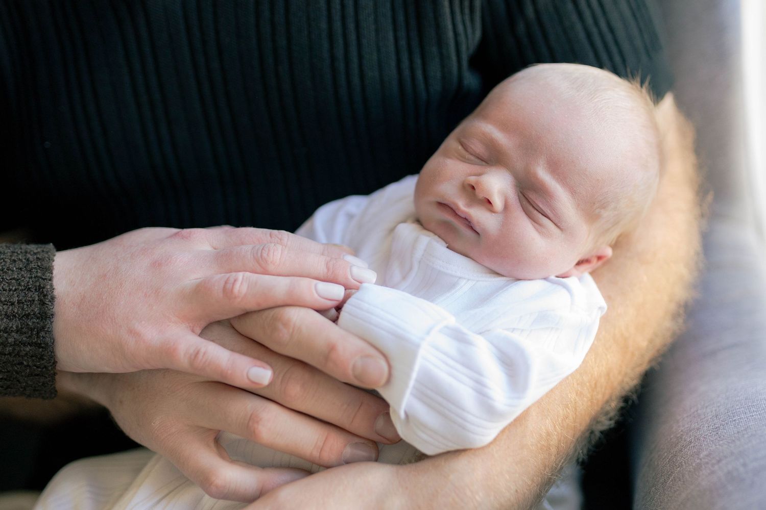 Close up of newborn in dad's arm with parents hands holding him Melton Newborn photography