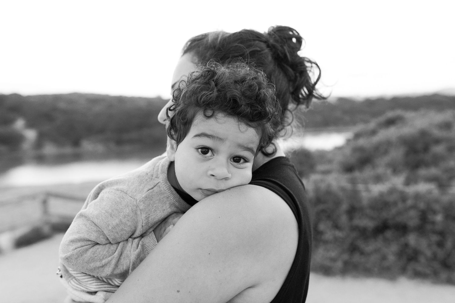 Toddler cuddling mum with his head on her should Outdoor family session Torquay