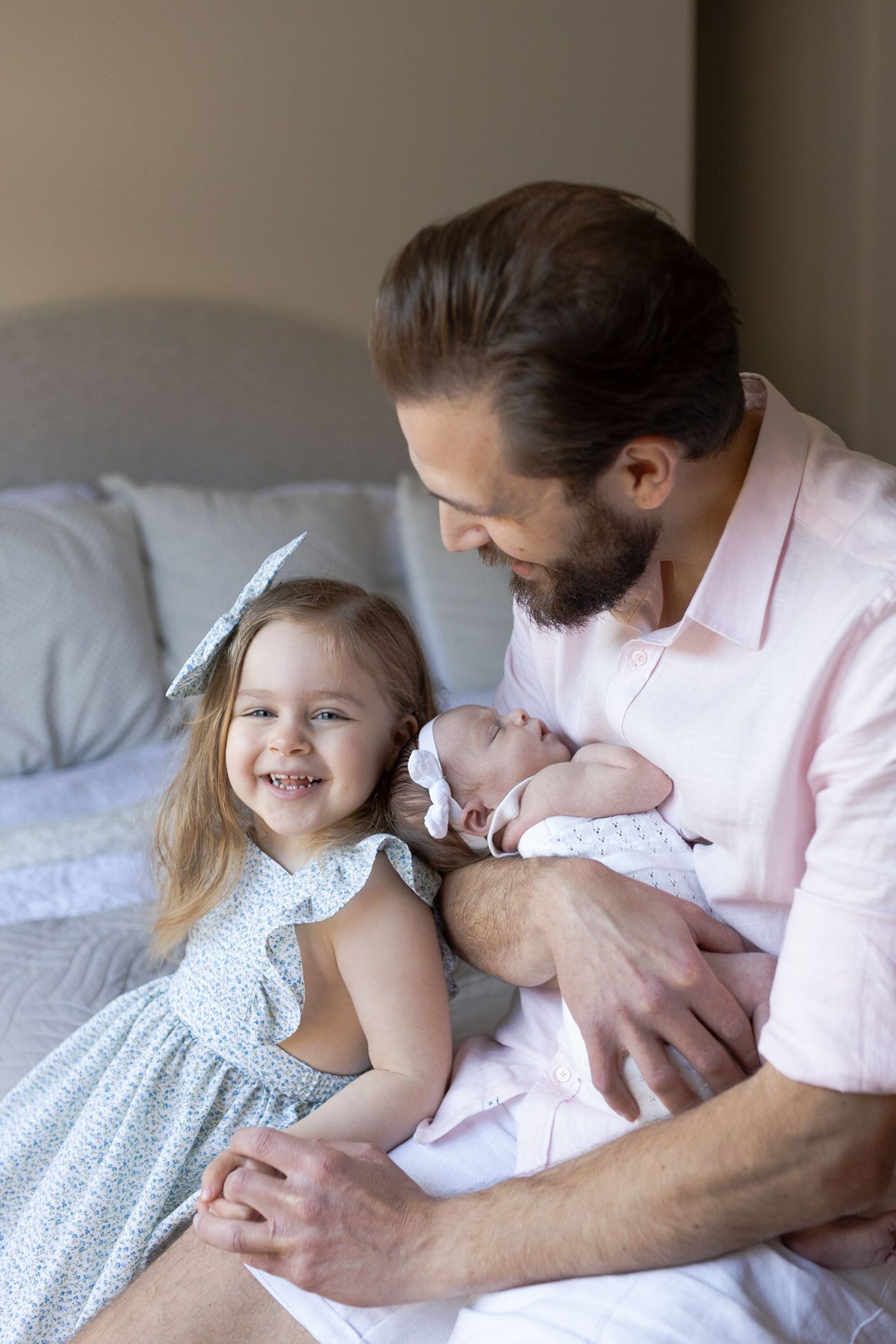 Dad holding newborn girl and big sister smiling Dad holding newborn girl at home newborn session Caroline Springs Melb Victoria