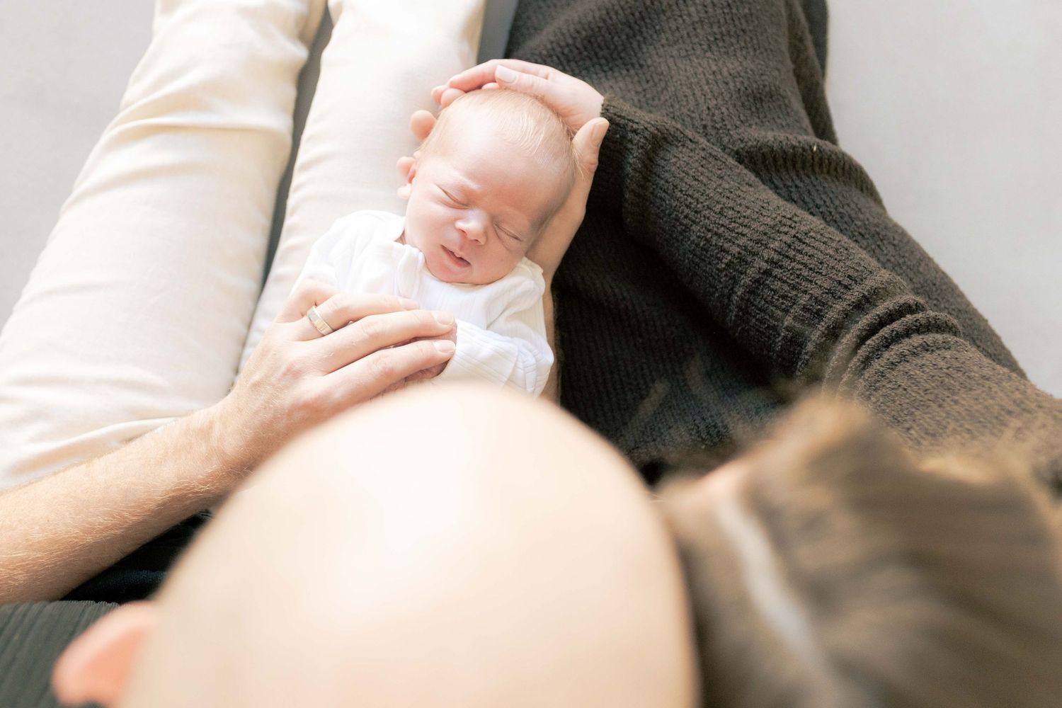 Looking down from on top of the parents head looking down at the newborn boy lying in their laps Newborn photography Melbourne's West Melton