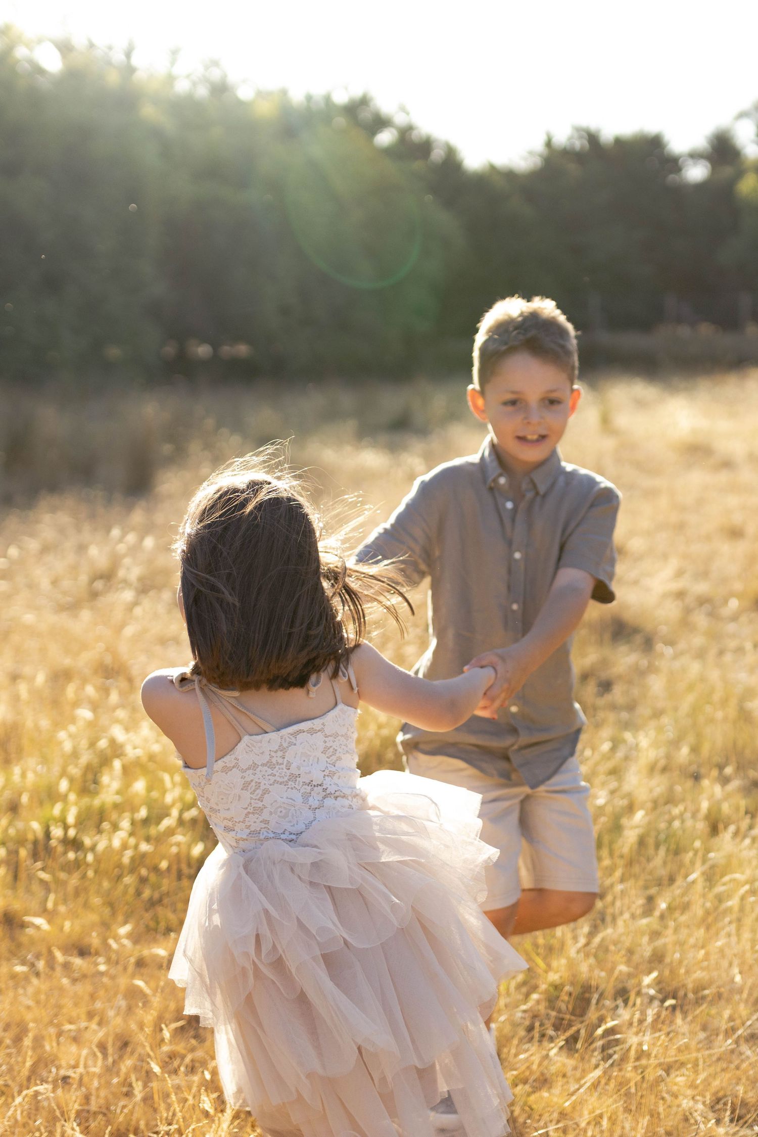 Brother and sister twirling around in a field Outdoor at home family session Gisborne Melb Vic