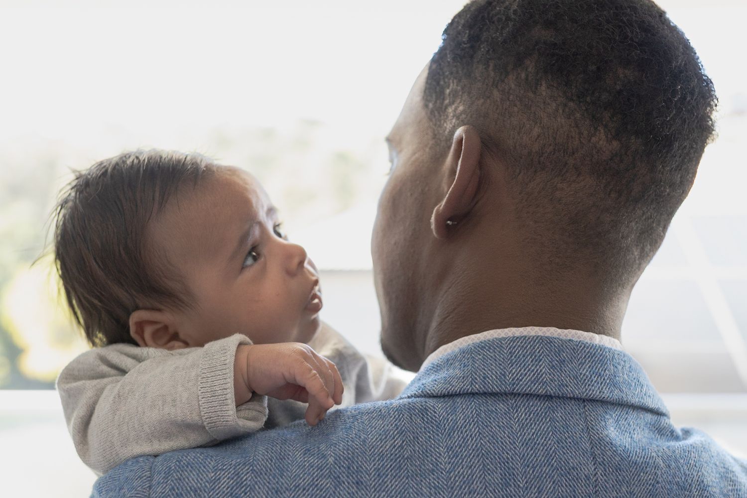 baby boy looking over his dads shoulder At home family session, sunshine north melb vic