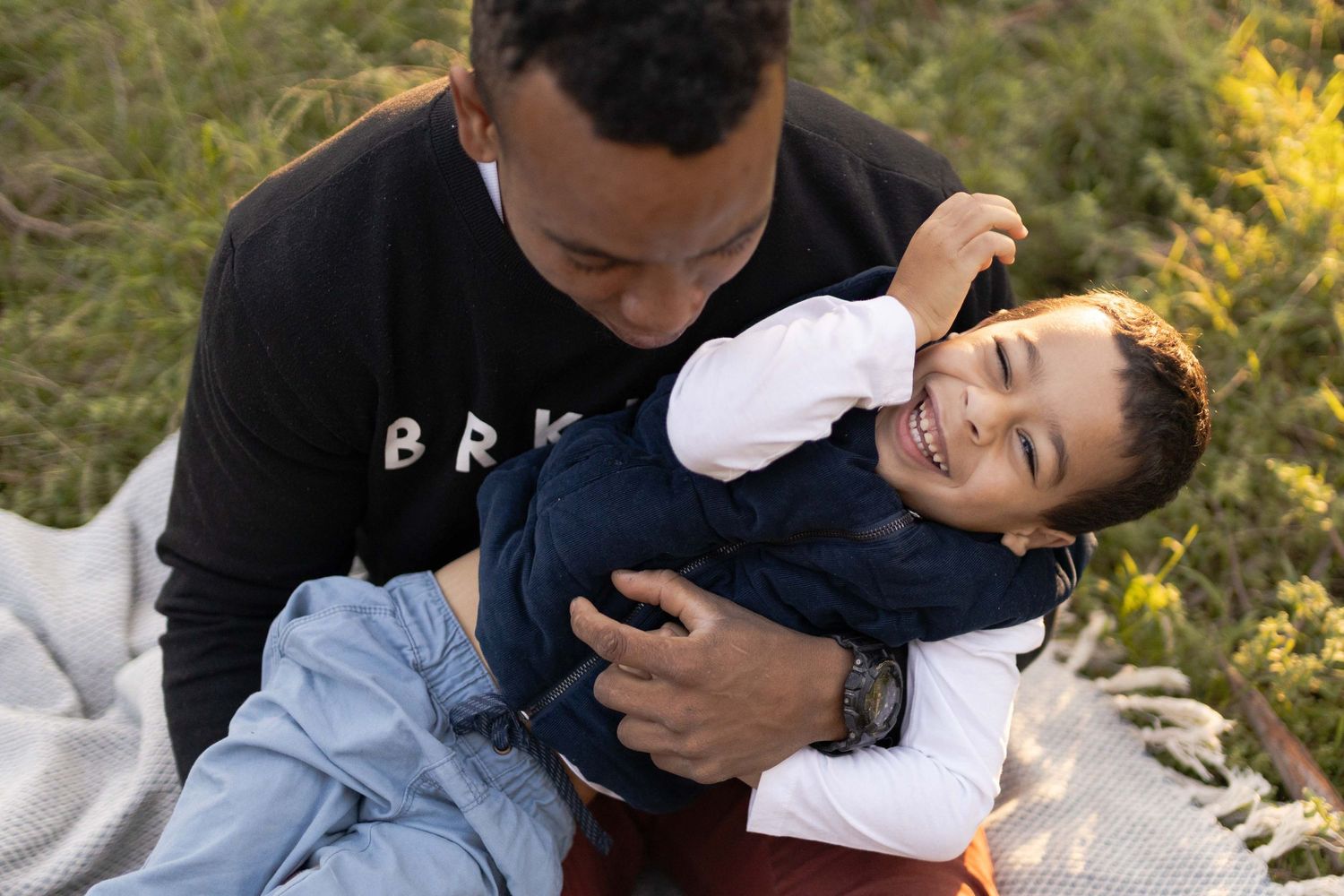 Son tickling his son who is laughing on a white blanket
Outdoor maternity session Sunshine Melb Victoria