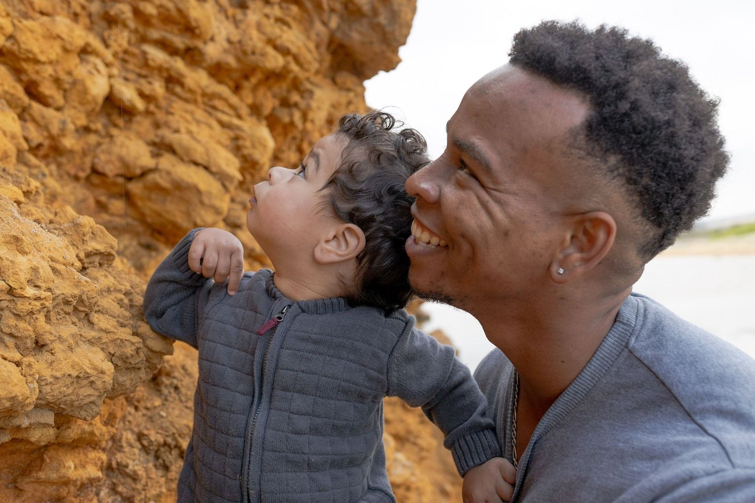Father and son looking at a cliff on the beach at the beach Outdoor family session Torquay
